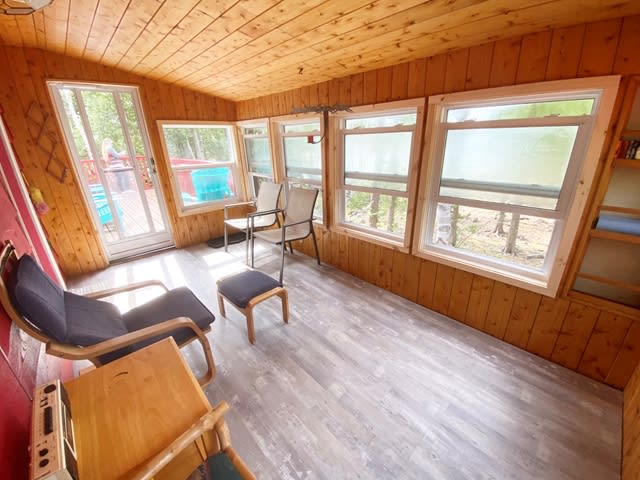 A screened-in wood sunroom