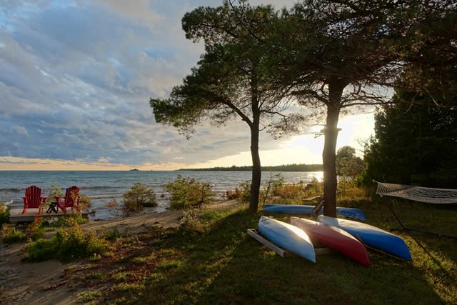 Upside-down canoes on the bank face the lake