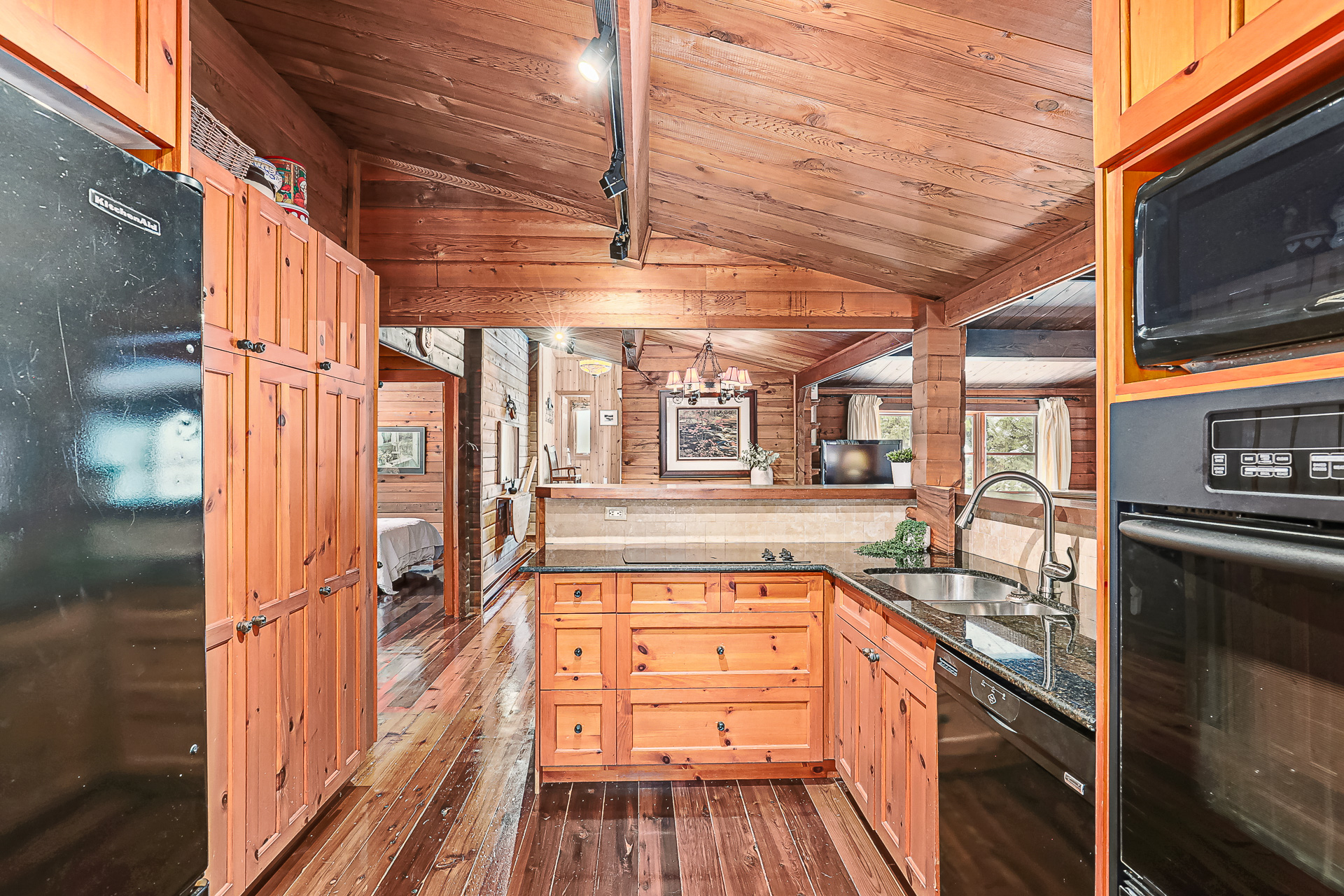 A wood kitchen with black countertops