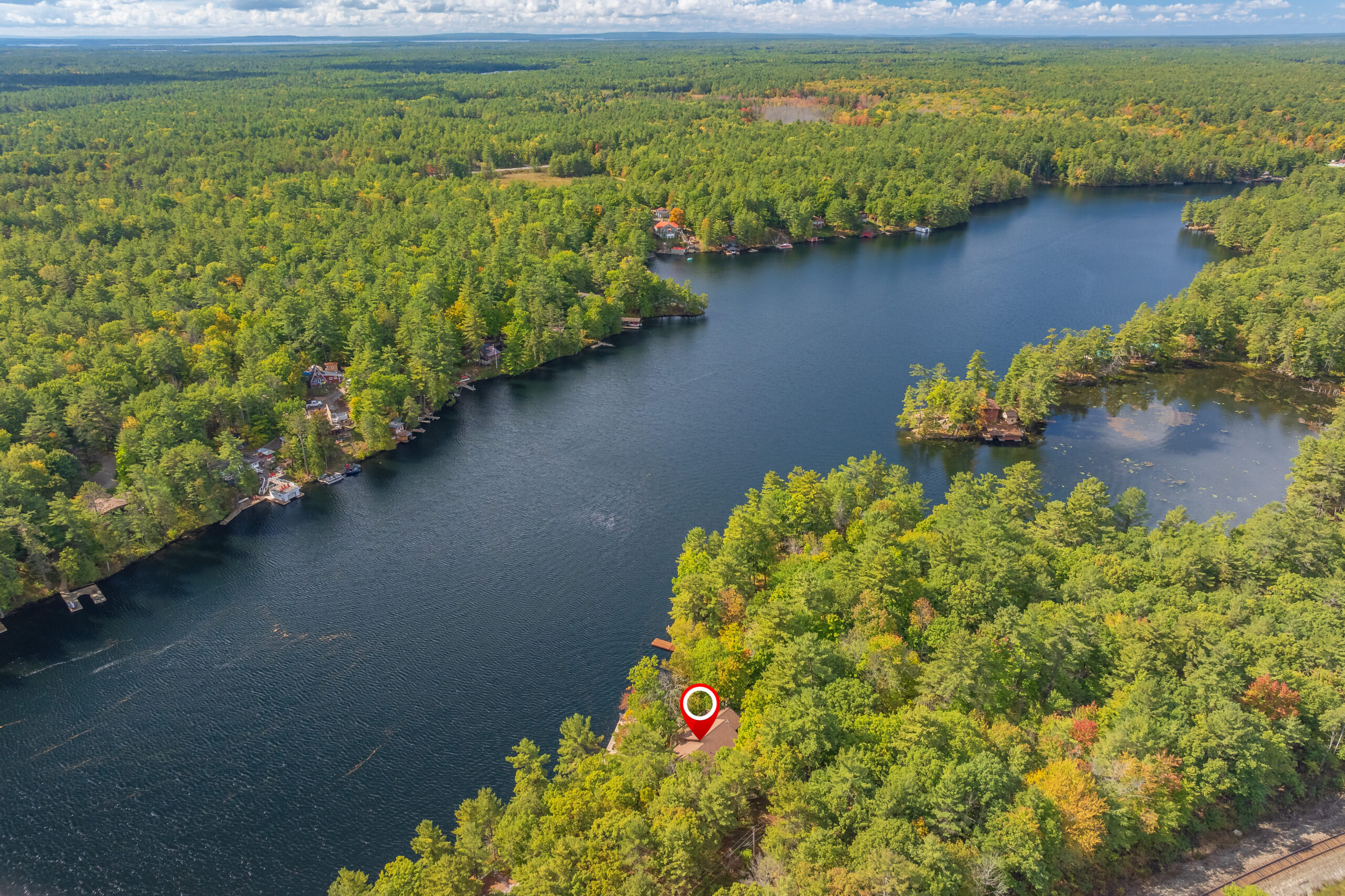 Aerial view showing the cottage, dock, and surrounding forest along the Severn River.