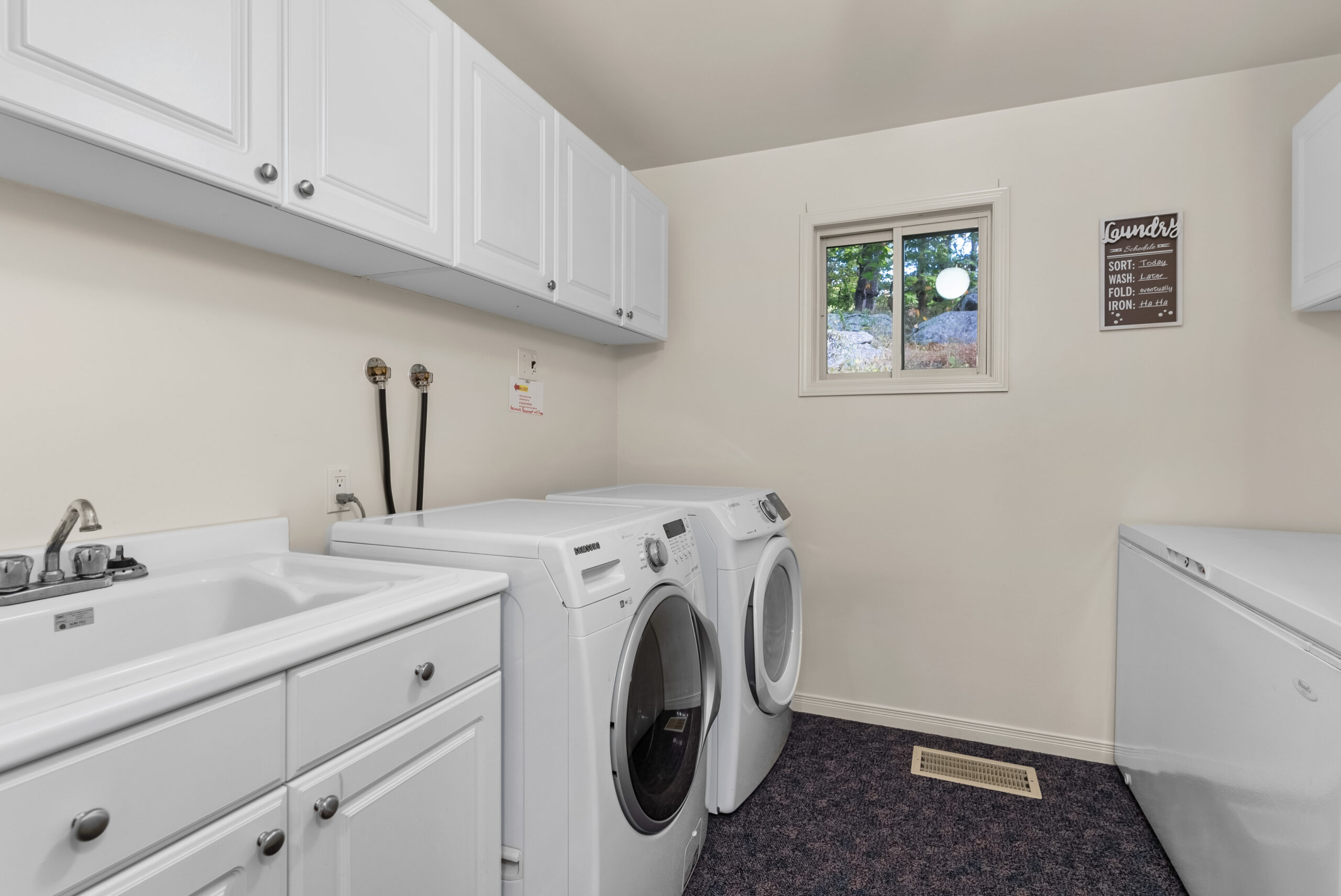 Laundry room with washer, dryer, cabinetry, and a bright window.