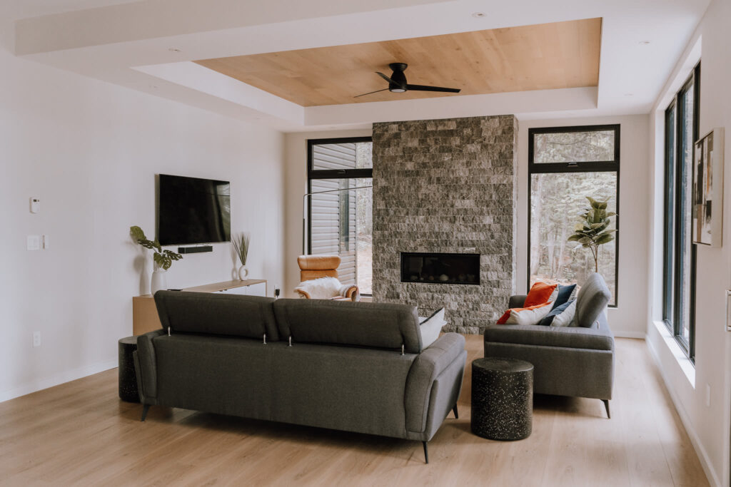 A grey couch faces a stone fireplace
