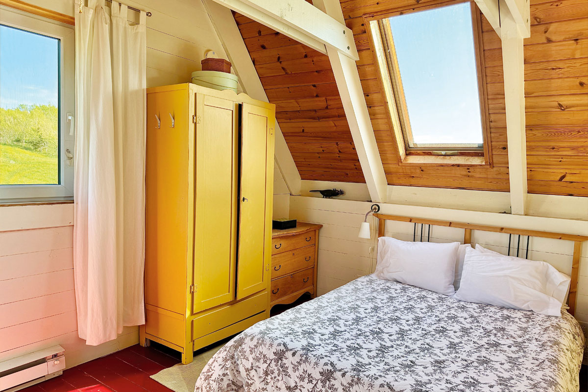 A bedroom with a yellow cabinet and bed with floral bedding