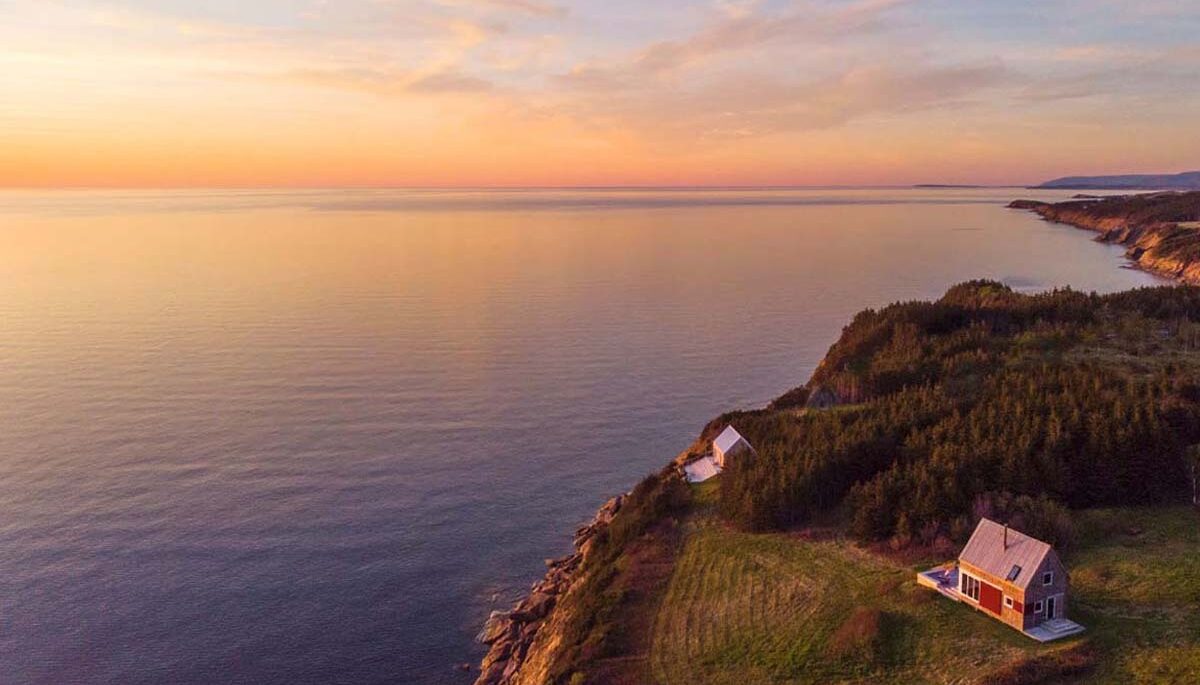 An aerial shot of cottages along the coast in Cape Breton