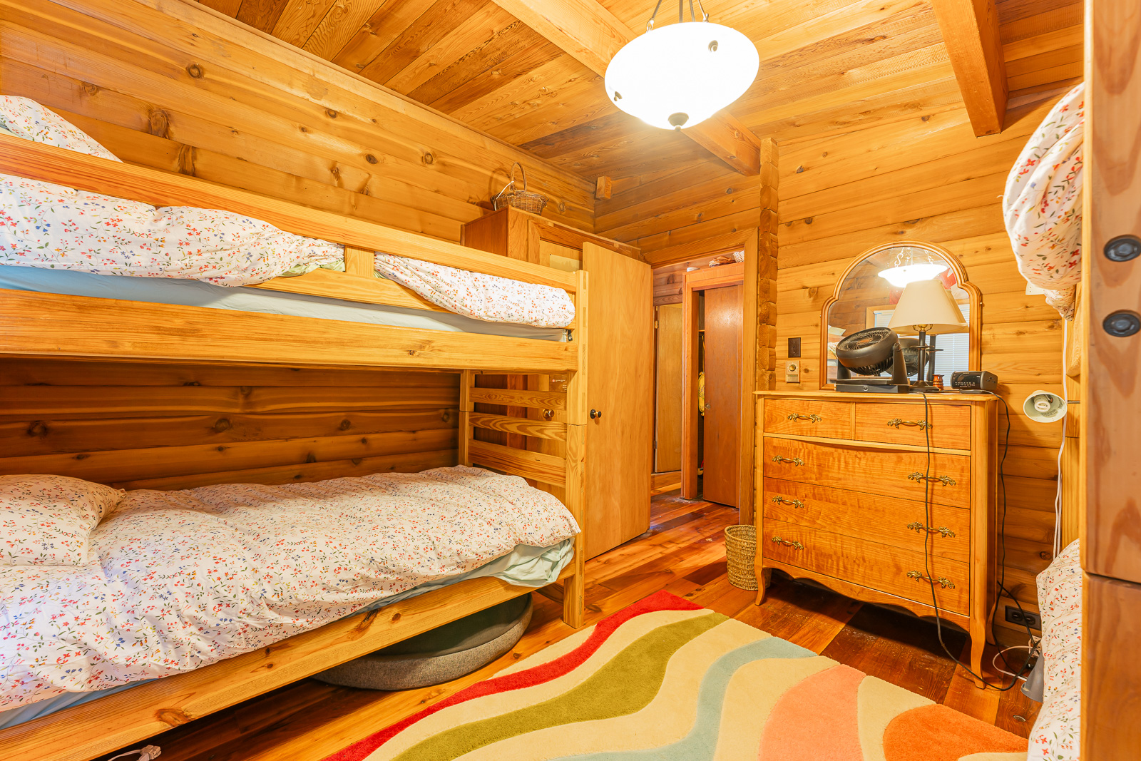 Two wood bunk beds on each side of a bedroom