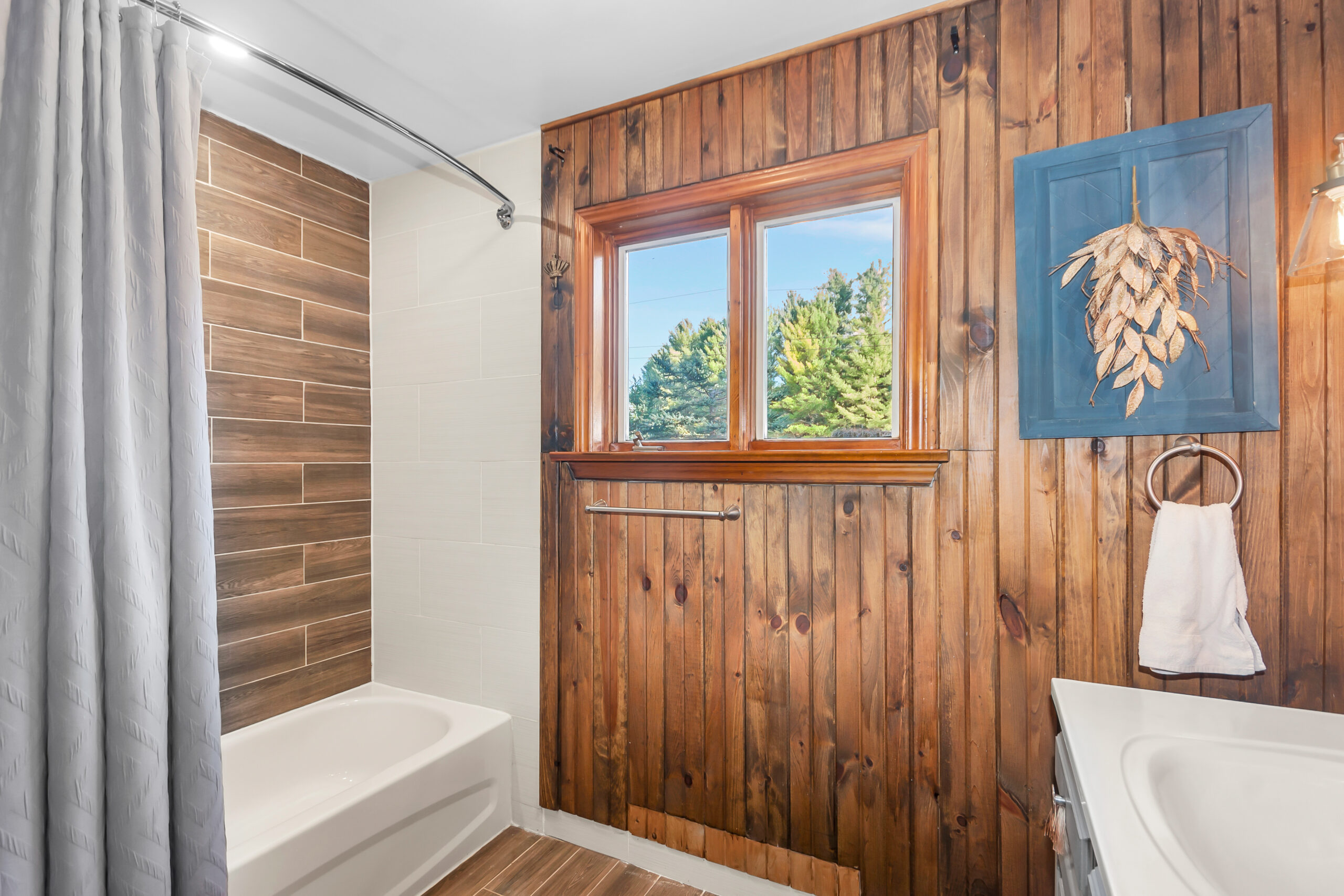 A wood-paneled bathroom with a white bathtub