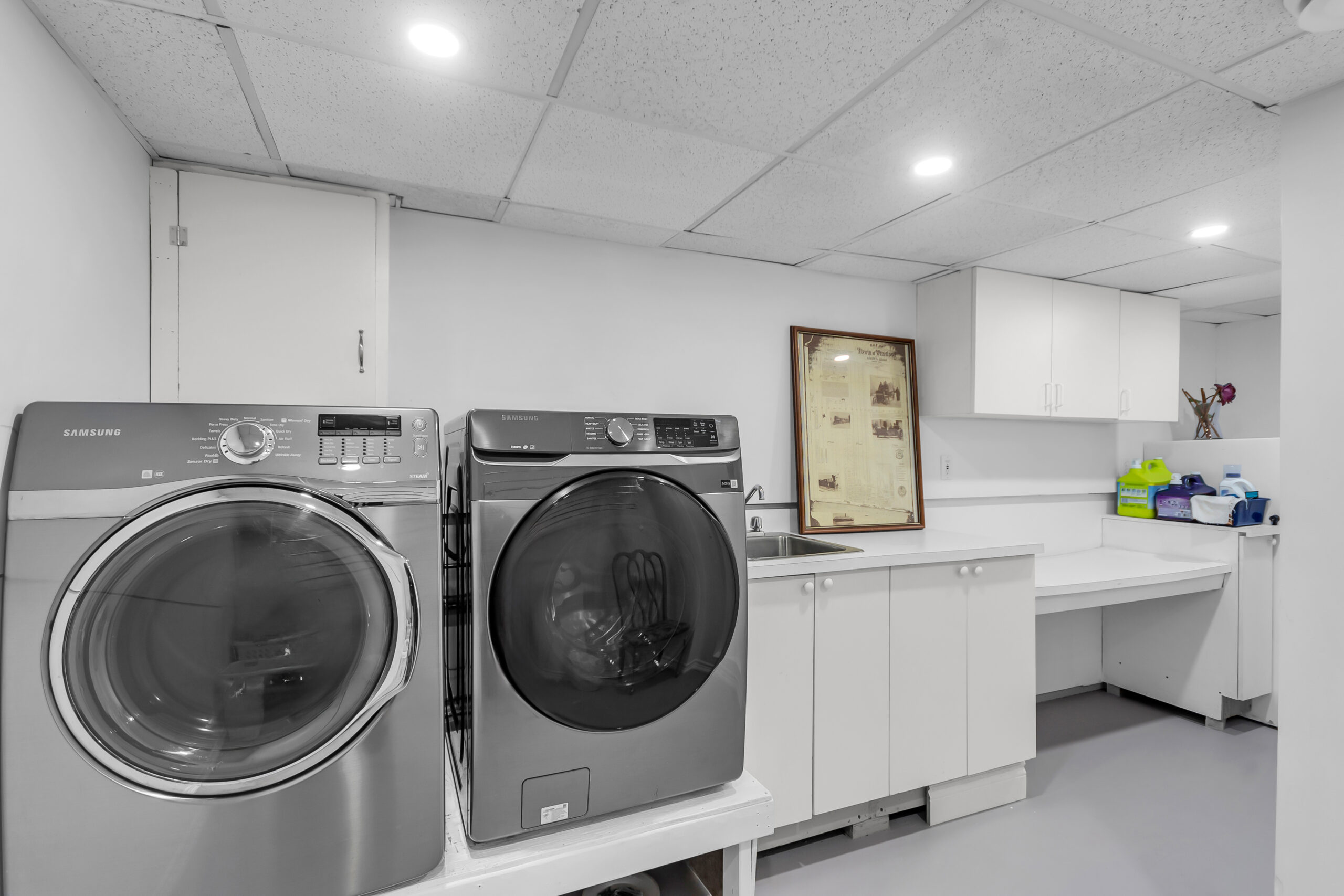Grey laundry machines in a white room