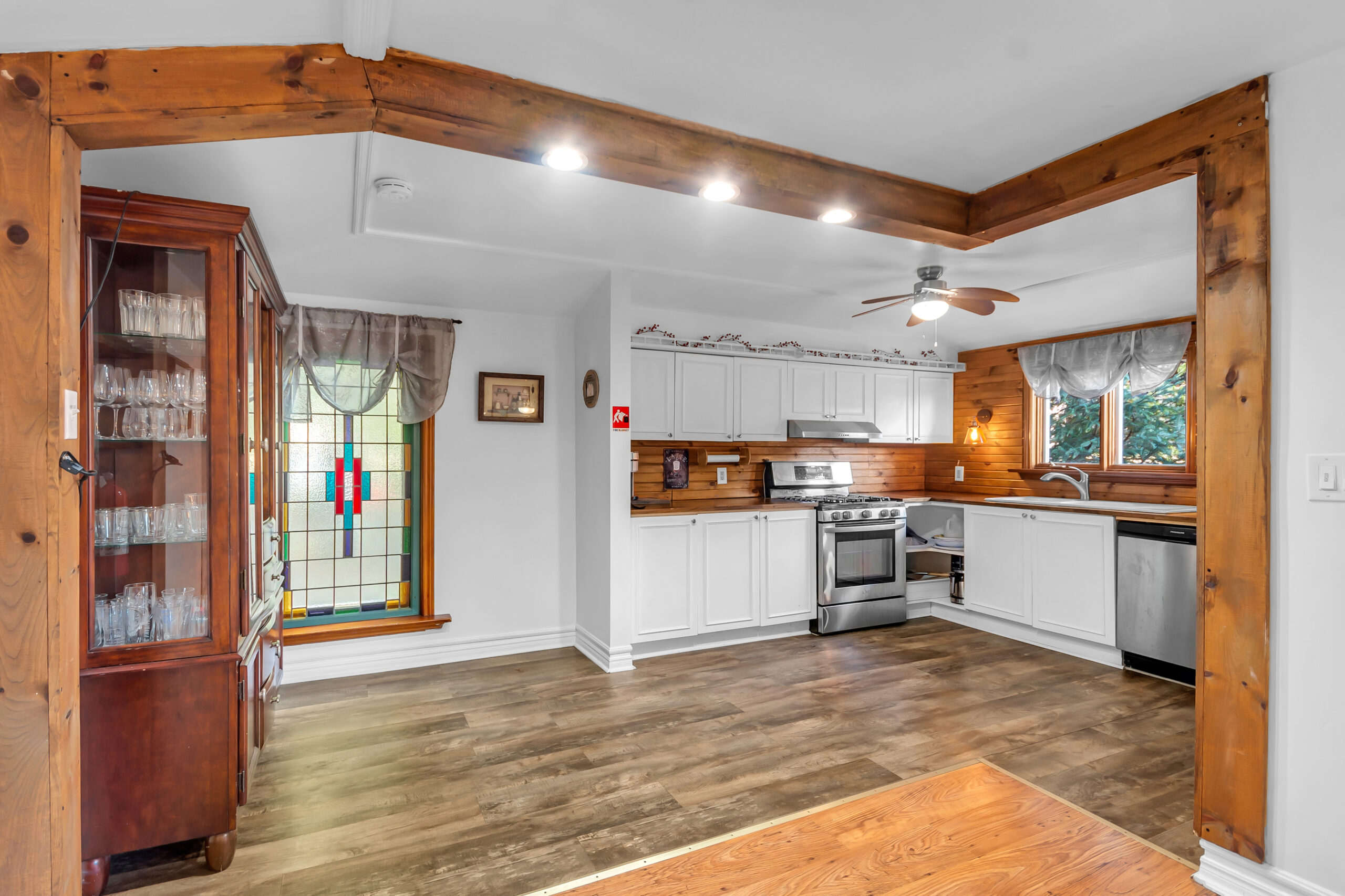 A white kitchen with wood moulding around the top of the ceiling