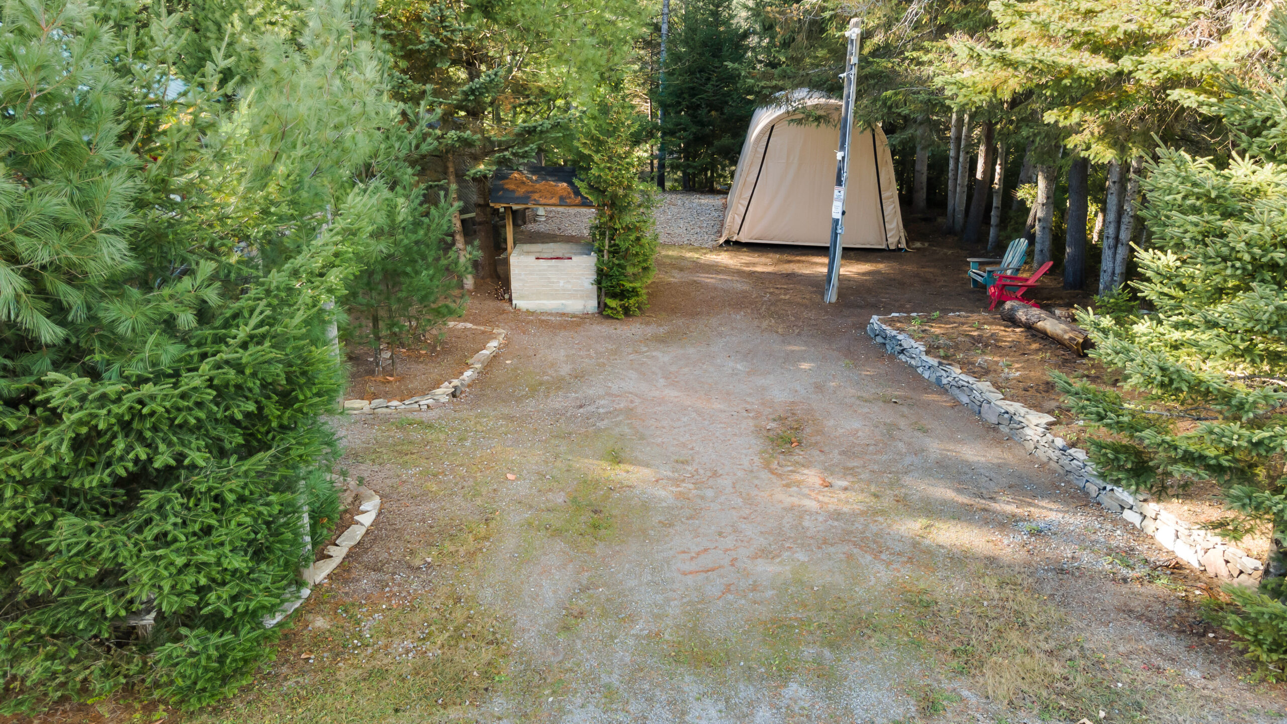 A beige soft-sided garage on a dirt road