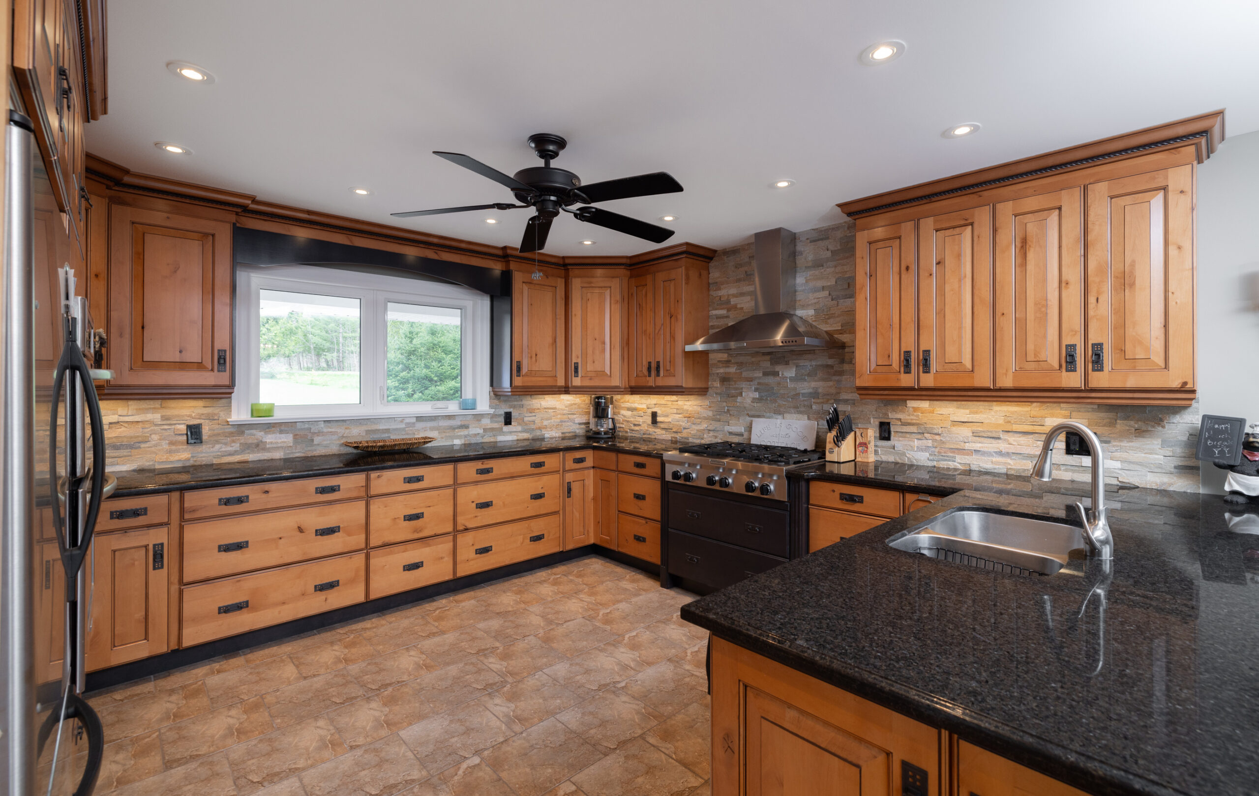 Kitchen with wooden cabinets and black countertops