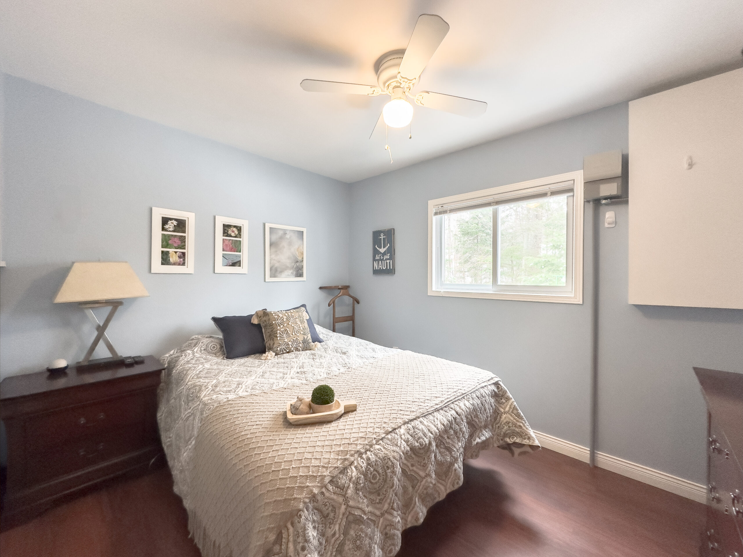 A white bed in a light blue room