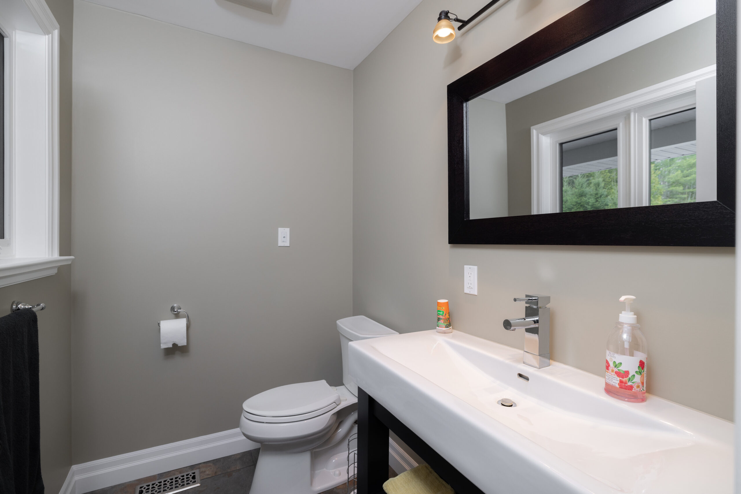 Bathroom with a toilet, a sink, and a mirror.