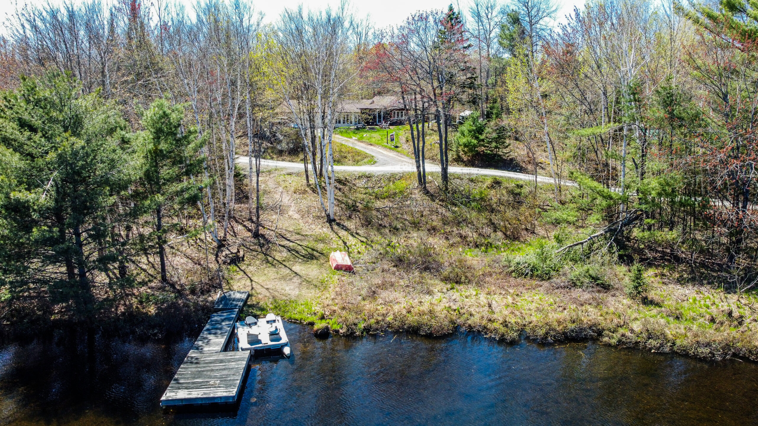 A cottage set back from a lakeside waterfront