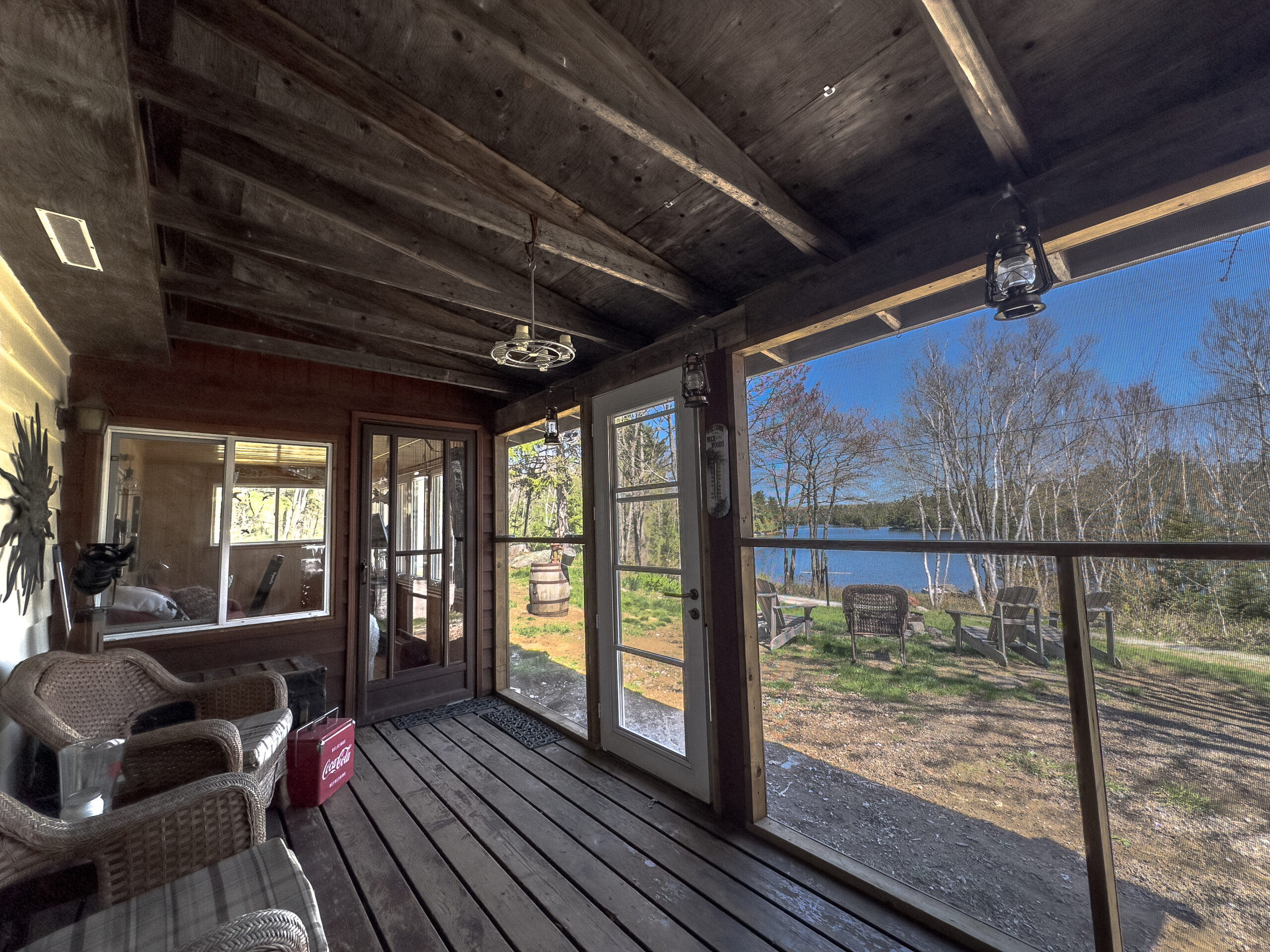 An empty screened-in wood porch