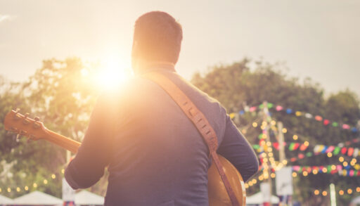 Man playing guitar at an outdoor live music event
