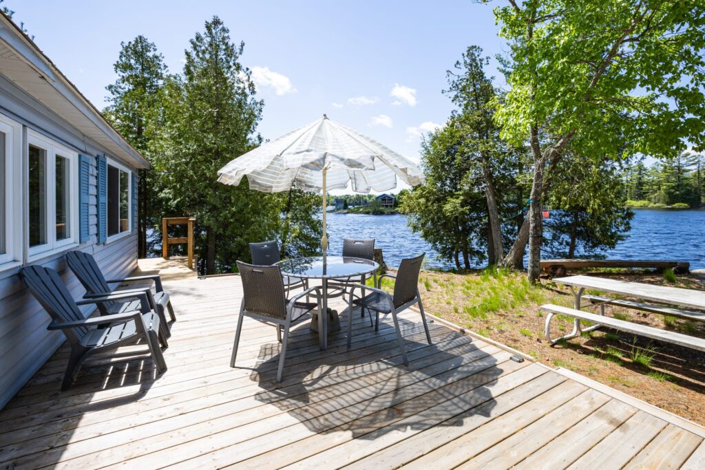 Lakeside deck with Adirondack chairs and dining table overlooking Bear Lake