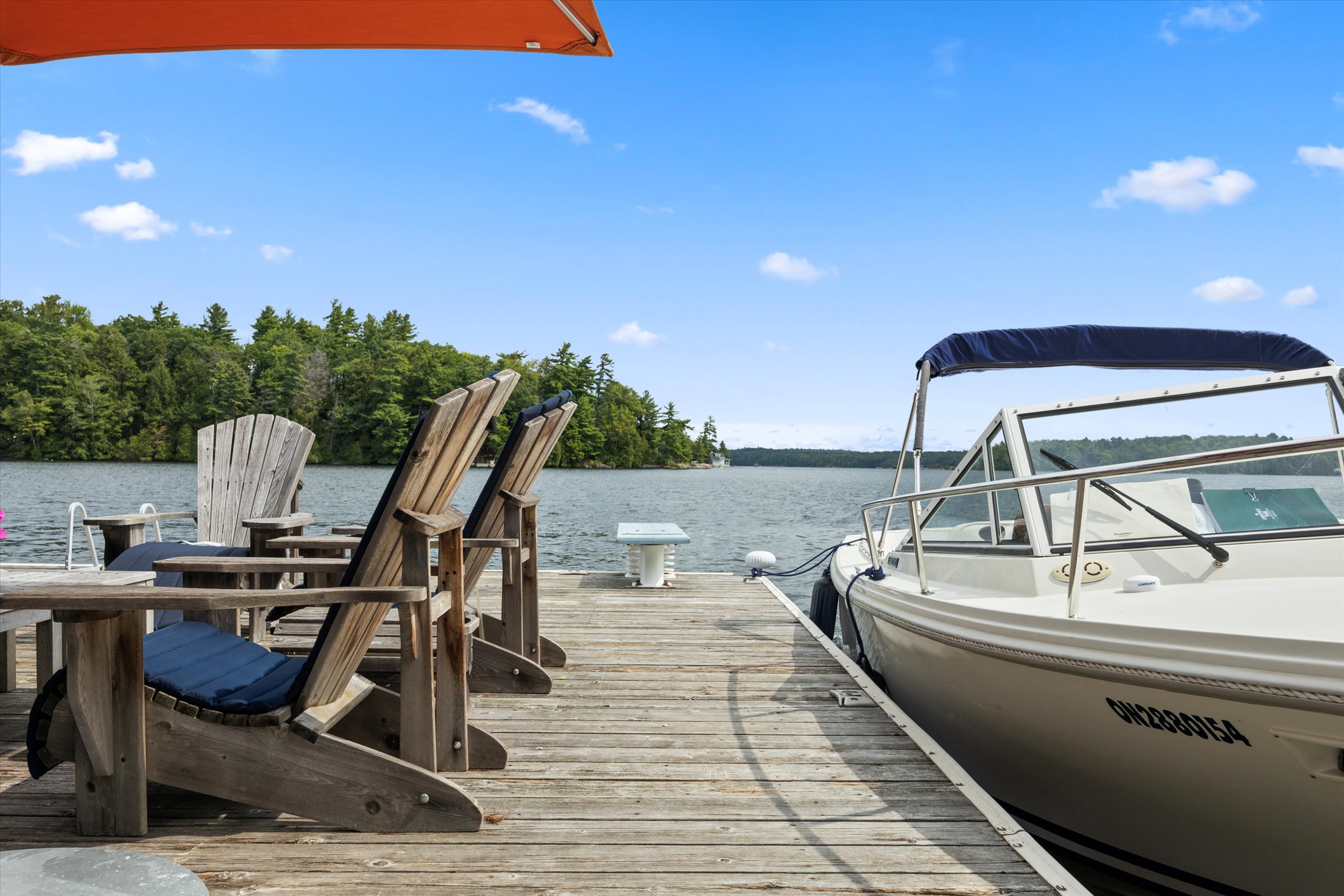 Picture-perfect dock scene with moored boat and open water under a bright blue sky