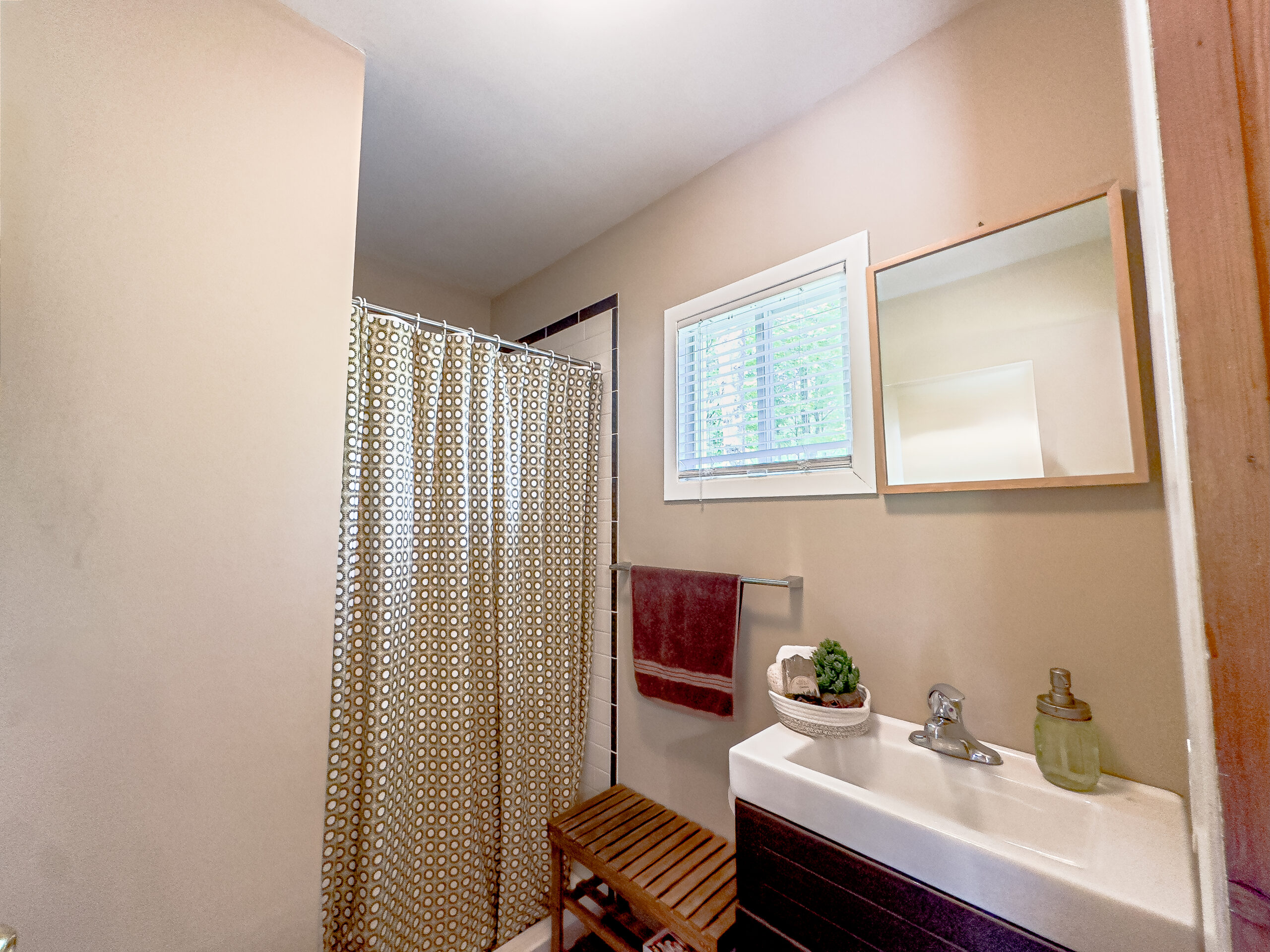 A small bathroom with a dark wood vanity