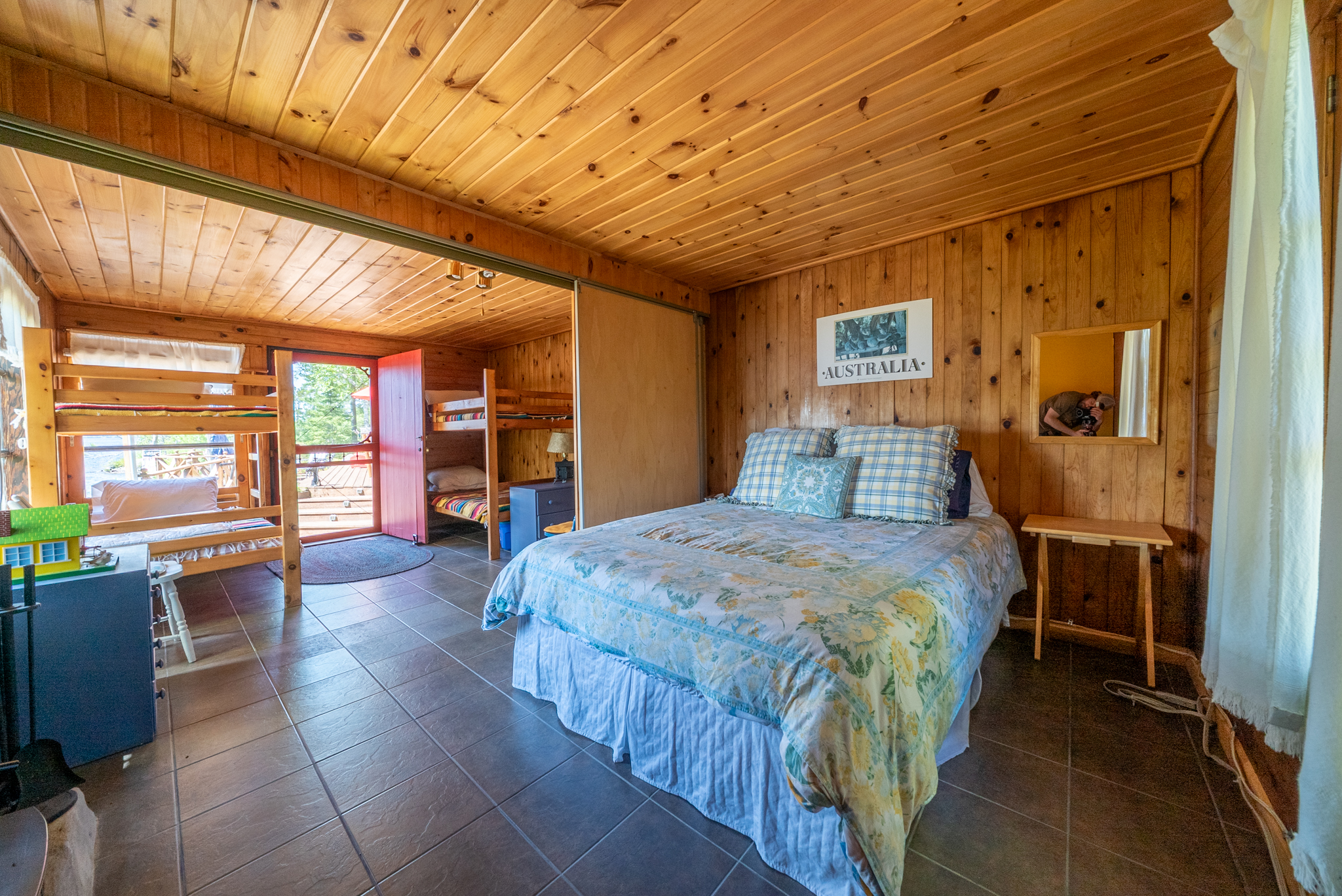 Cozy wood-finished bedroom with sliding glass doors leading to an outdoor deck