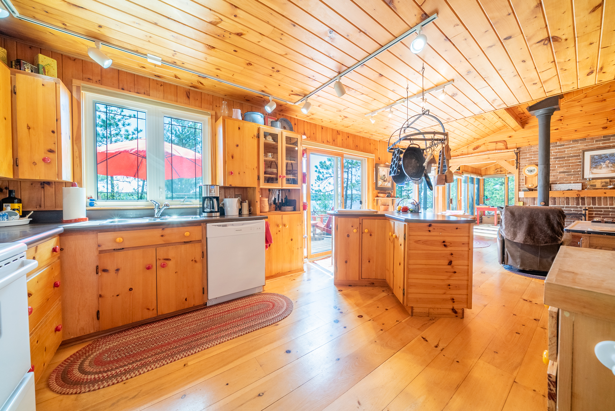Large kitchen area with pine cabinetry, tile floor, and bright overhead lighting