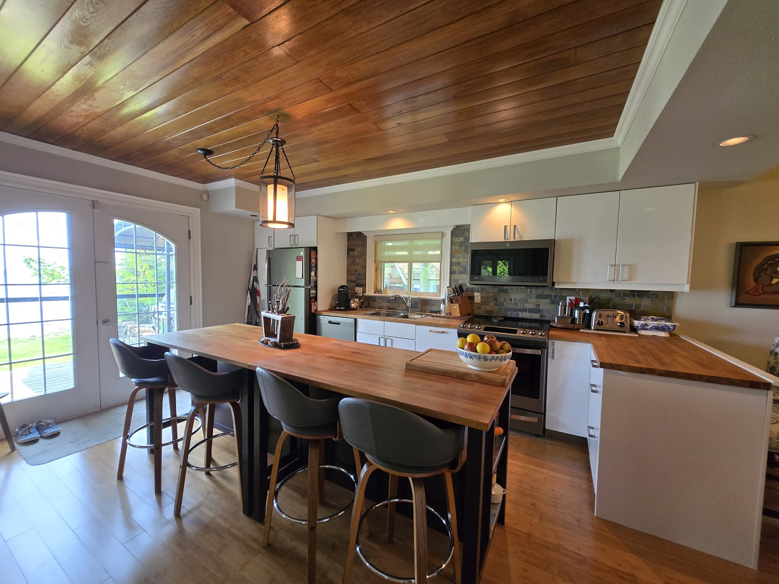 Spacious kitchen with wood ceiling, center island, and lake views