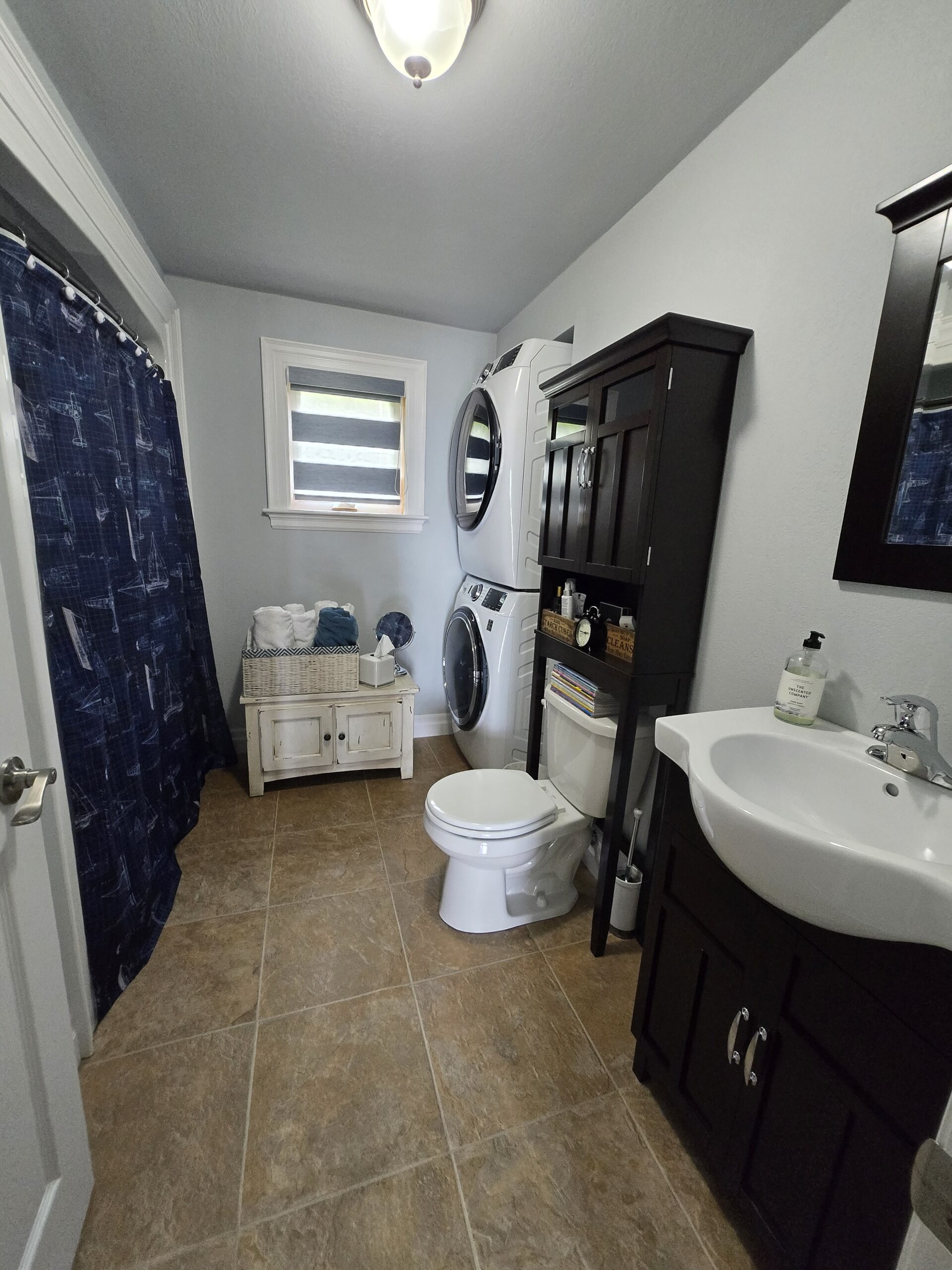 Main bathroom with tiled floor, dark vanity, and modern fixtures