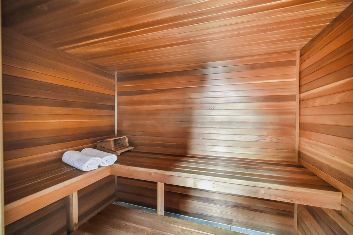 Cozy, modern cedar sauna with built-in bench seating and soft ambient light