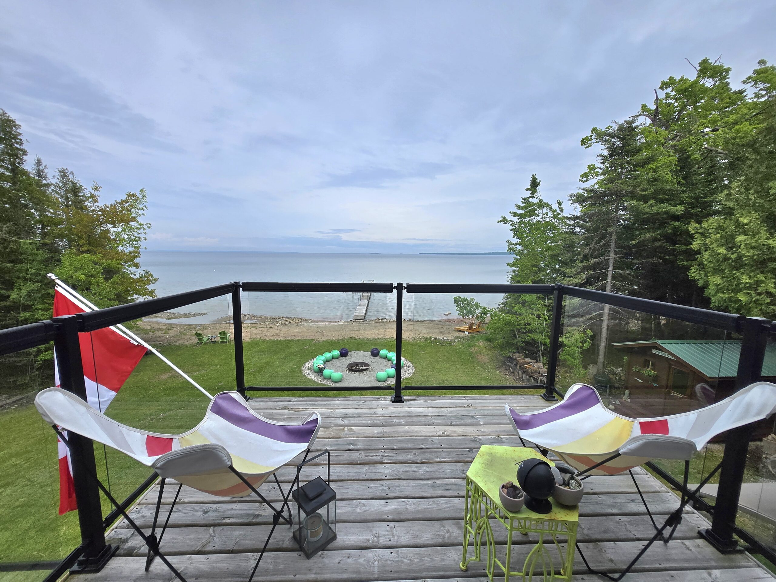 Deck overlooking Lake Huron with Muskoka chairs and fire pit below