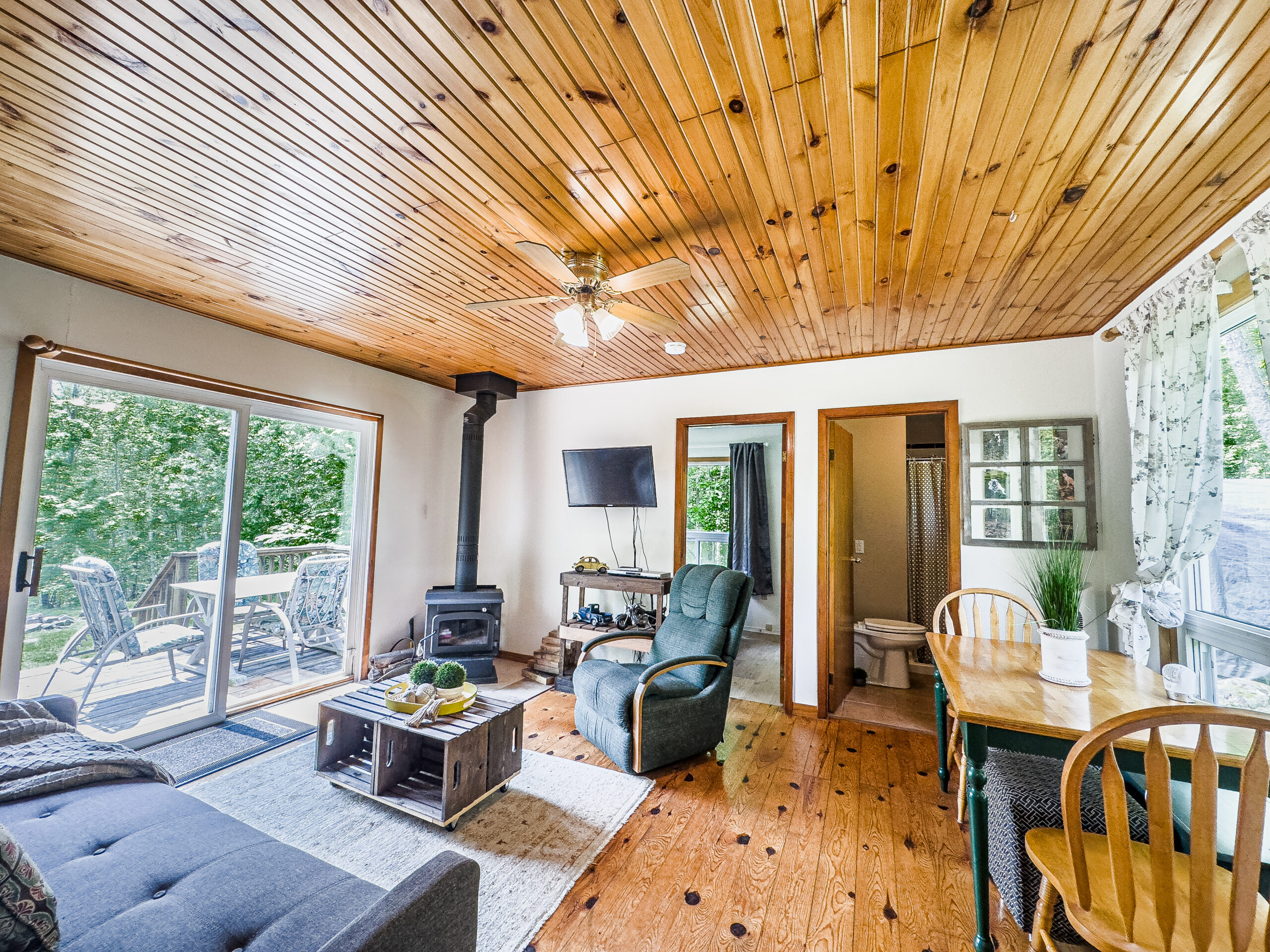 A grey chair next to a wood stove faces a grey couch