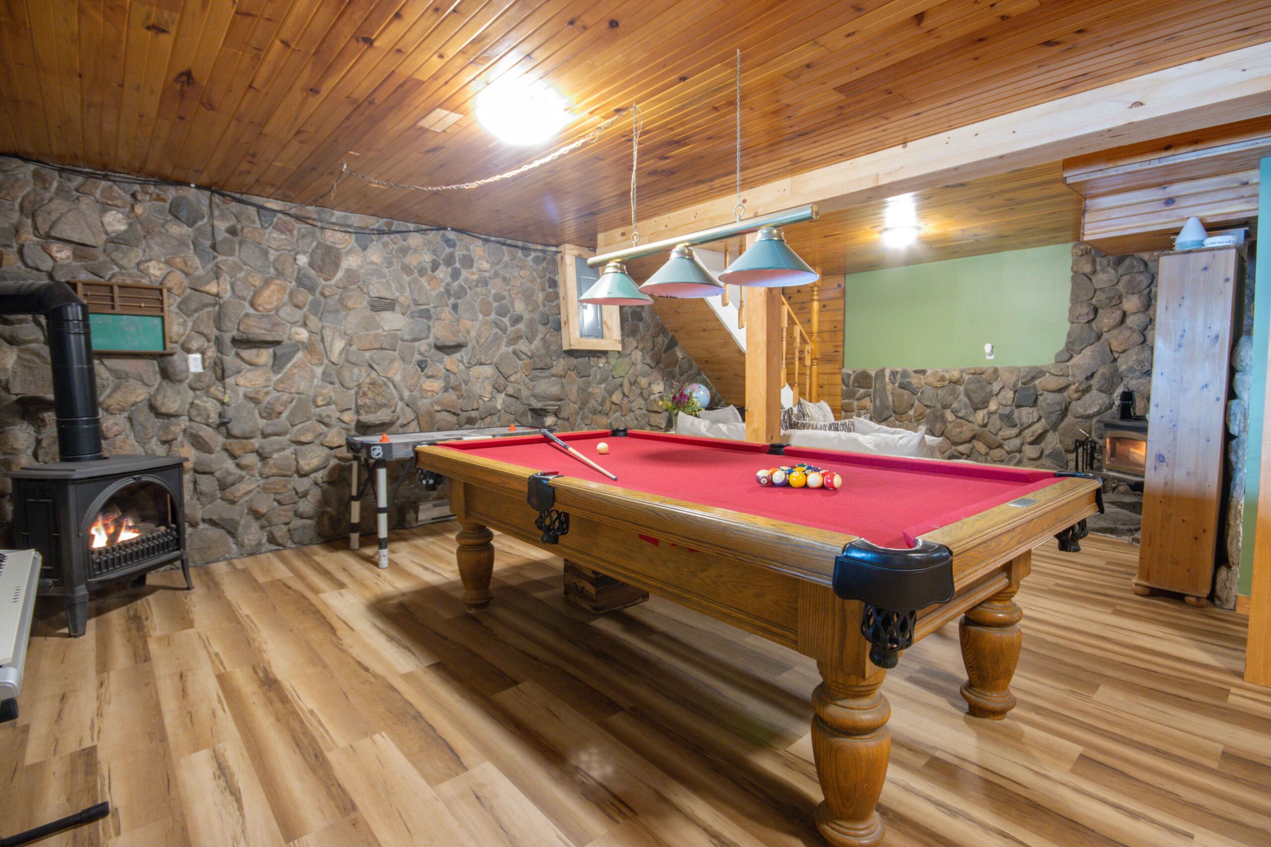 Recreational space with a pool table and stone accent wall.