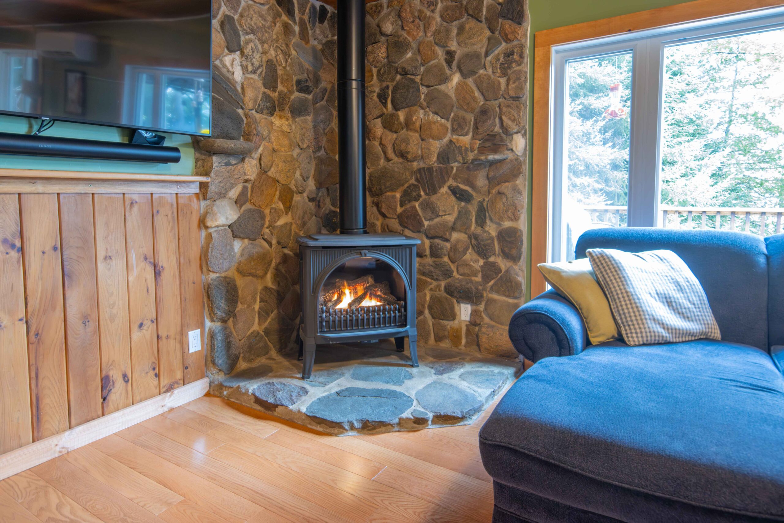 Rustic living space featuring a propane stove and picture window.