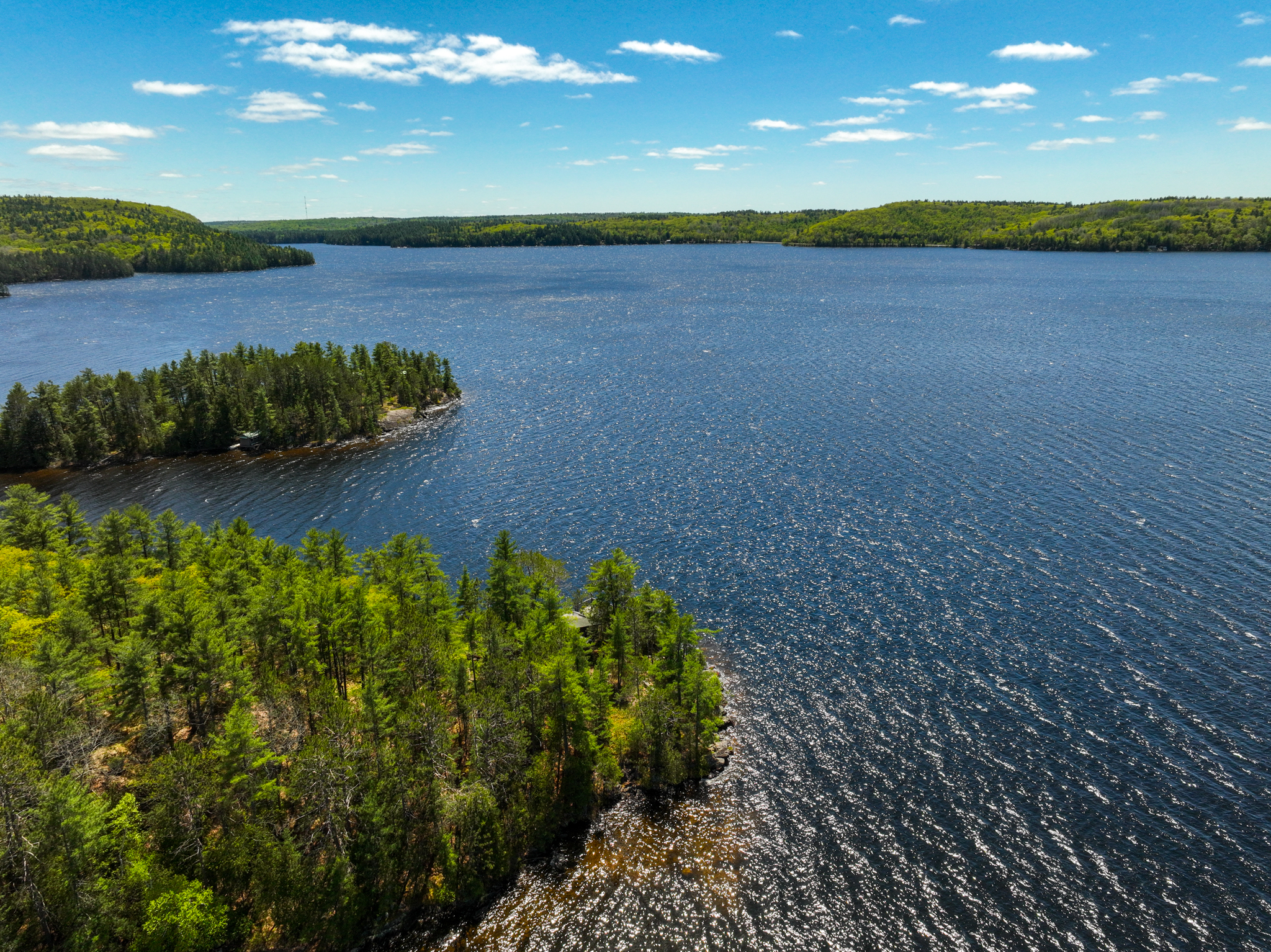 Expansive view across Mazinaw Lake with forested shorelines and deep blue water under a vibrant sky
