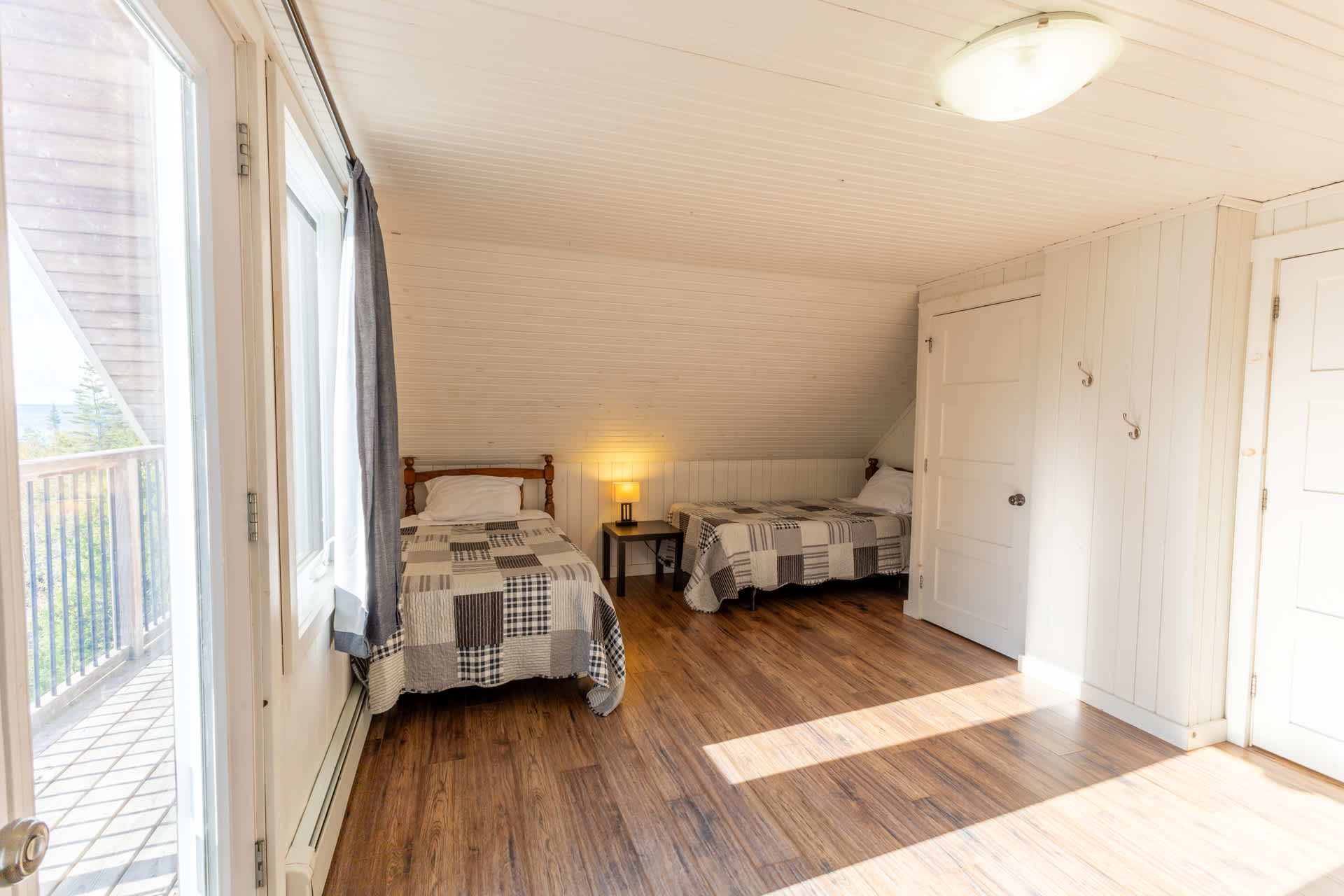 Two single beds with blue and white quilts in a white room