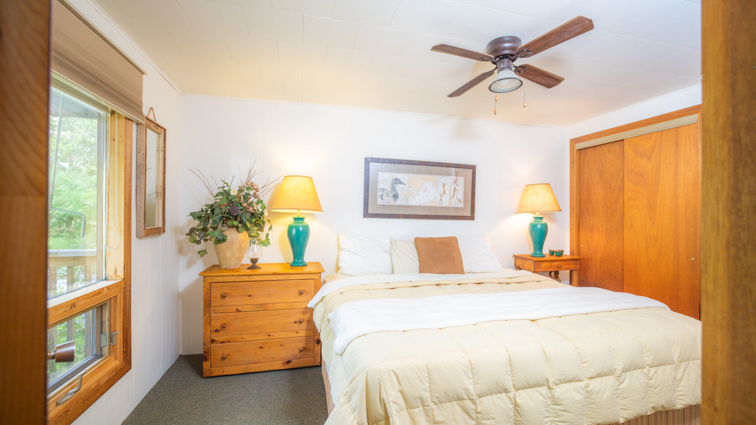 A white bed framed by two wood side tables