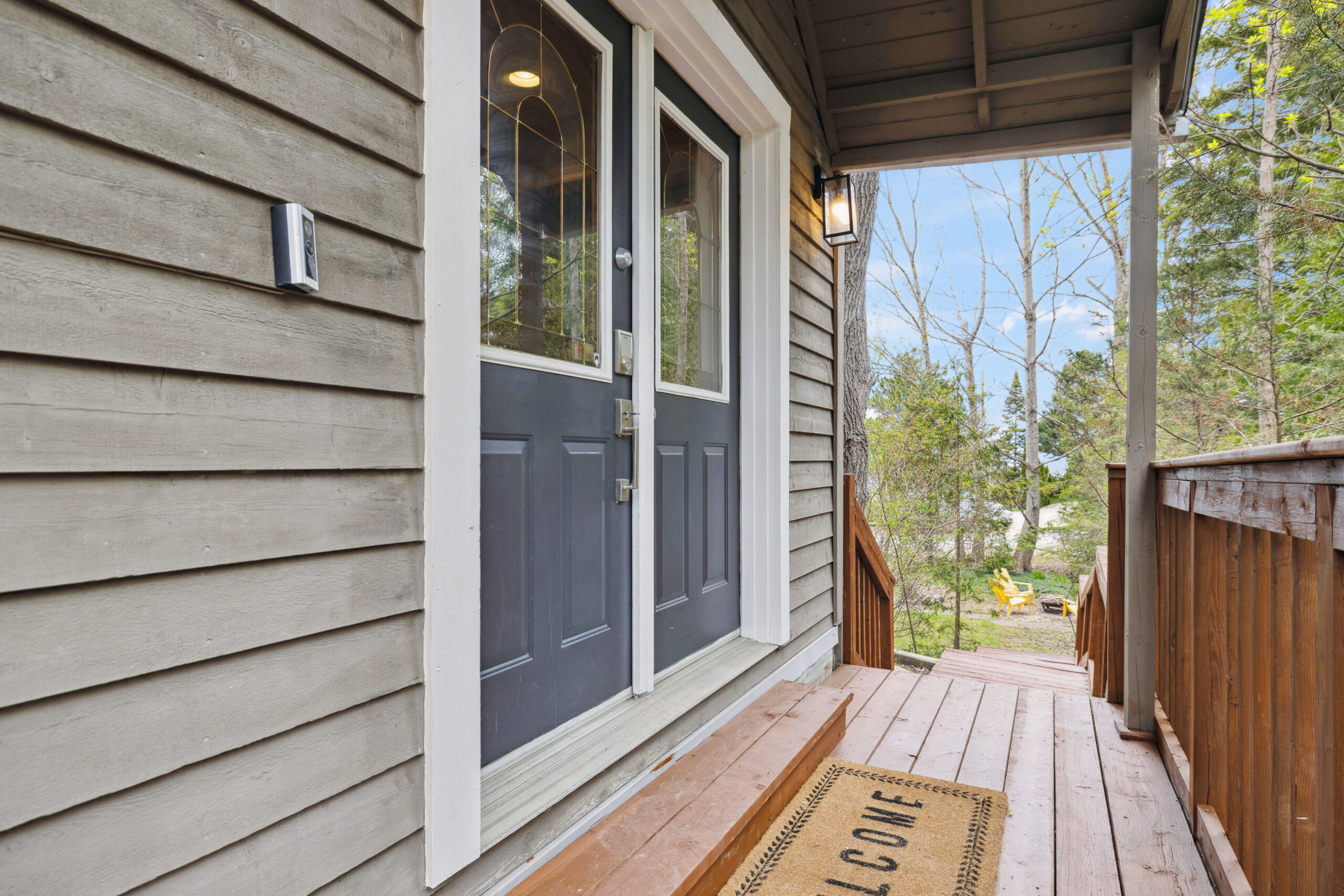 Blue double front doors on a brown wood-paneled cottage
