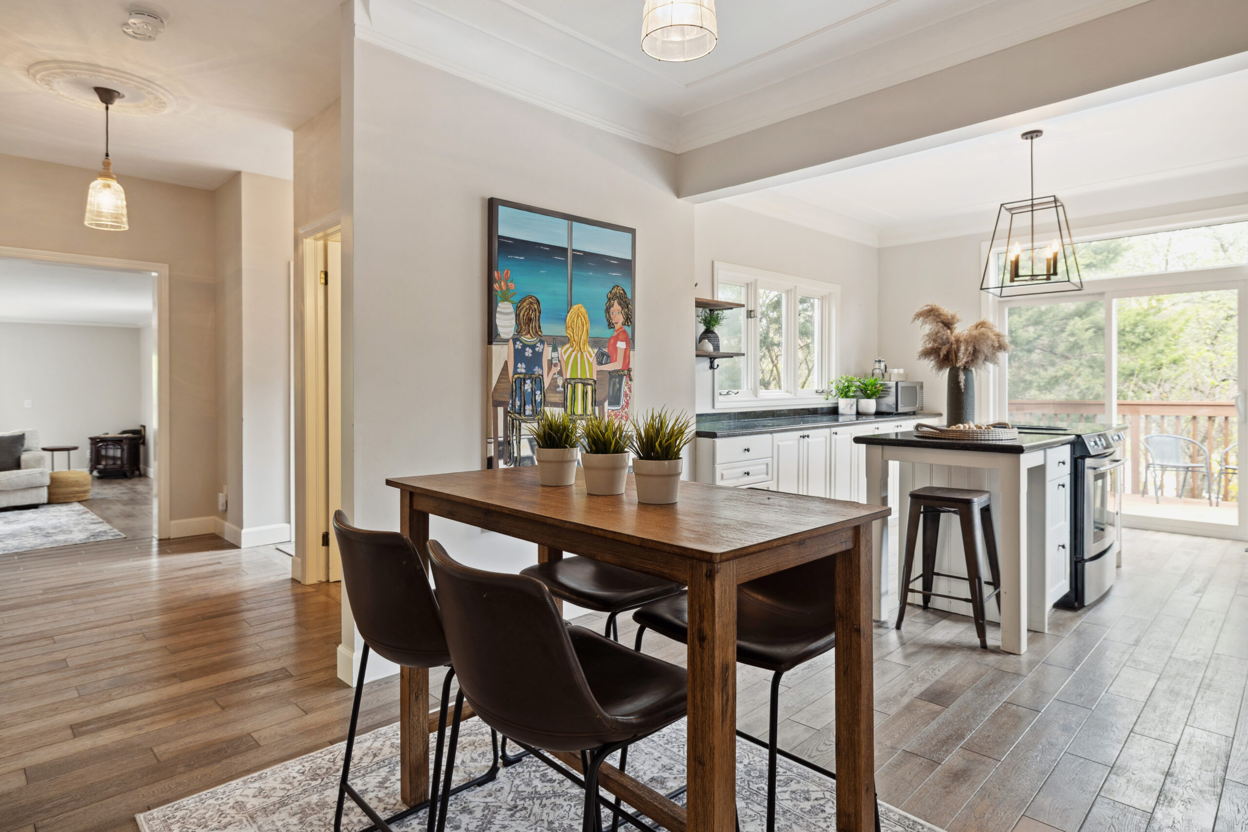 A high-top table with brown chairs in a white kitchen