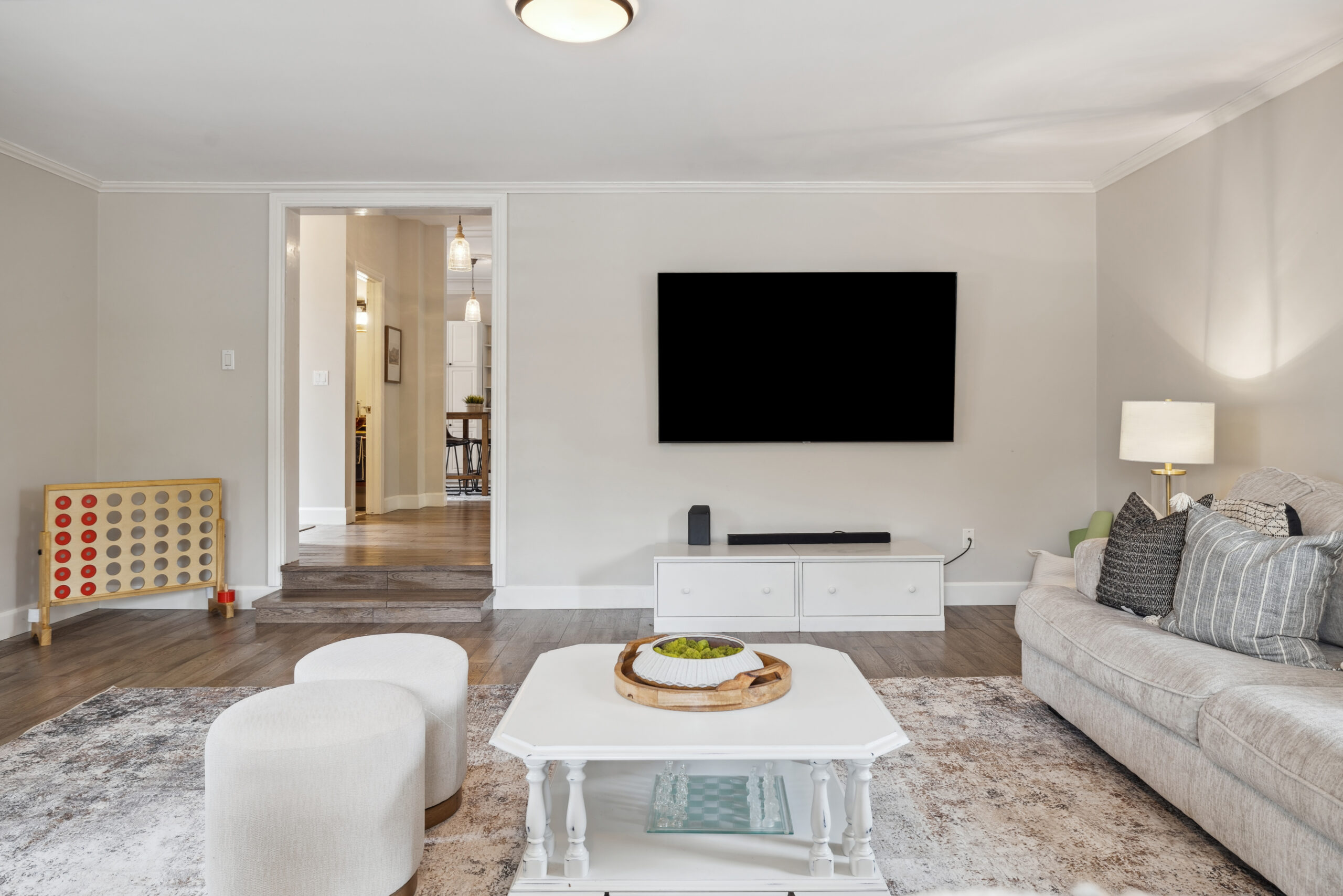 A TV mounted on the wall in a white living room