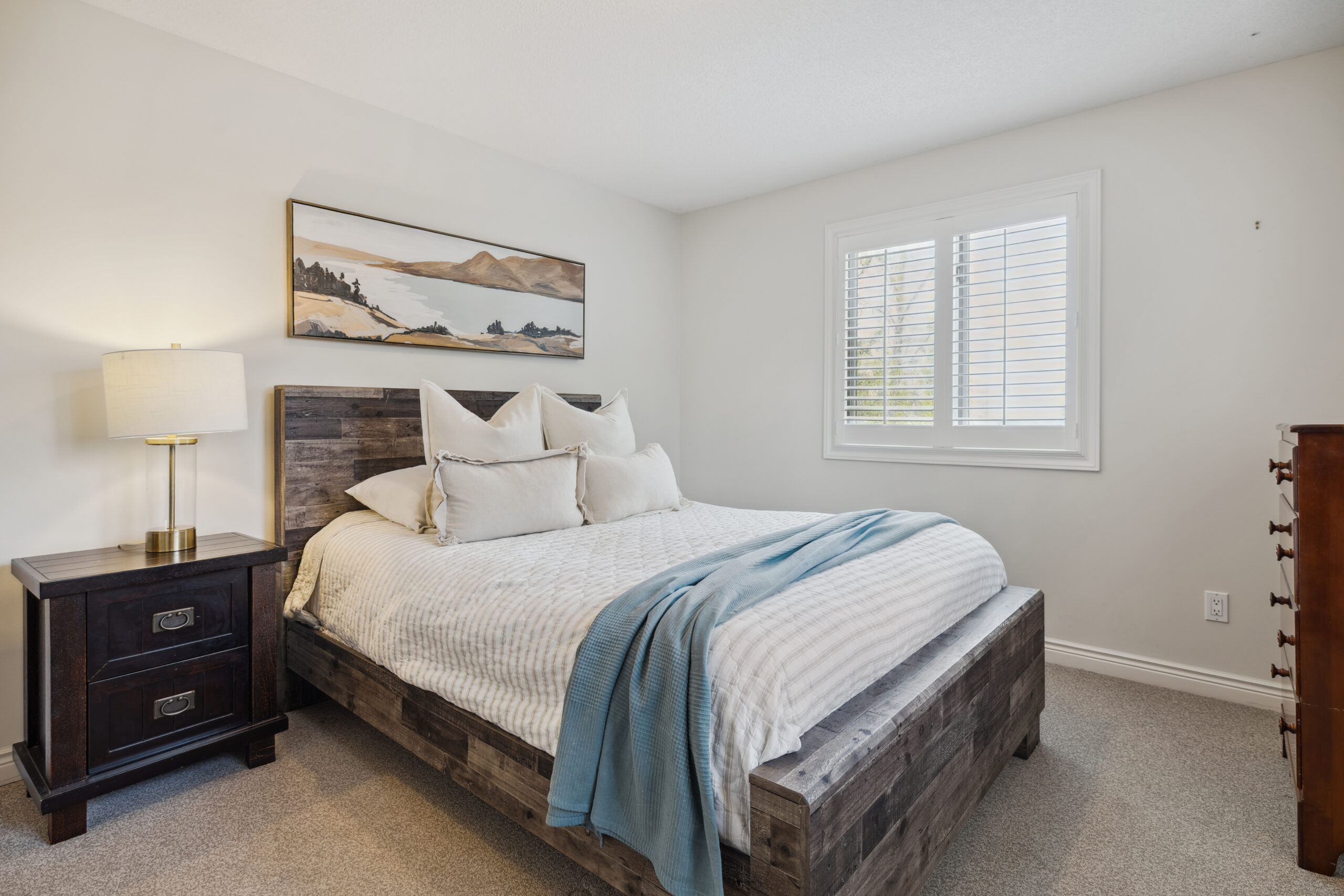 A white bed on a grey wood-grain bed frame
