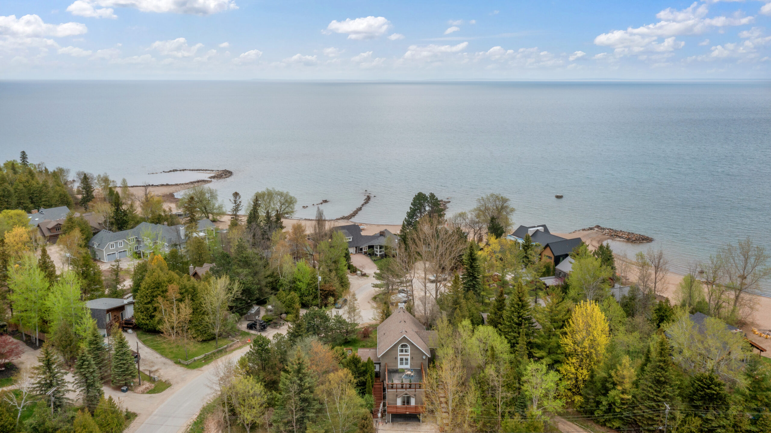 Aerial view of a brown wood-paneled cottage down the street from Georgian Bay