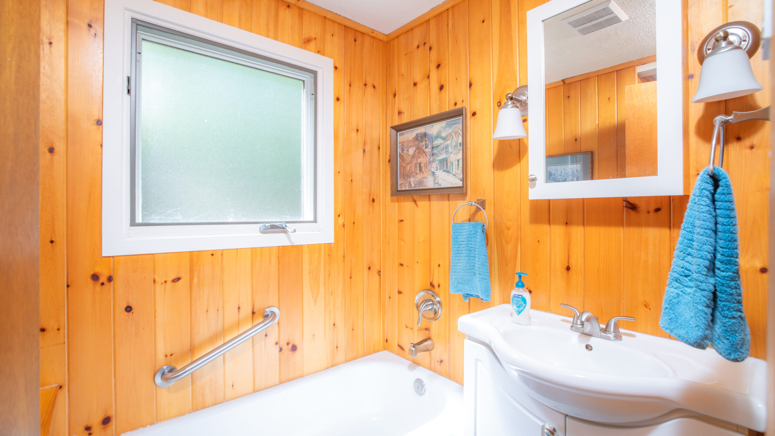 A white bathtub in a wood-paneled bathroom