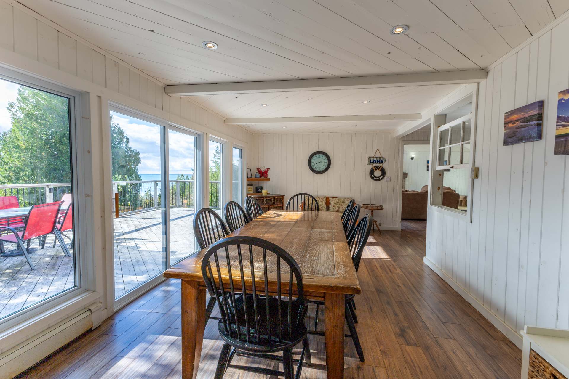 A wood dining table with dark brown chairs next to glass sliding doors