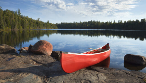 A red canoe resting on the rocks