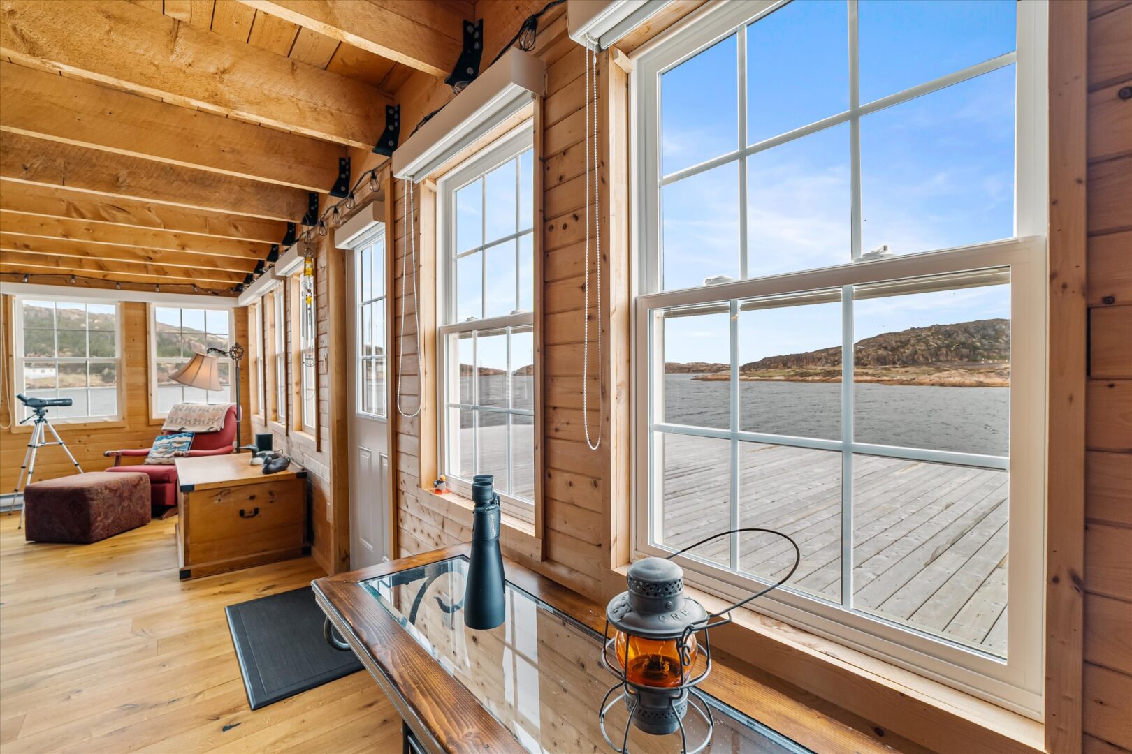 Cozy sunroom with nautical decor, large windows, and views of Deep Bay