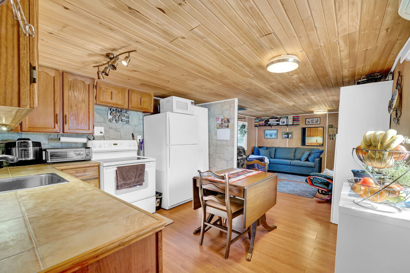 Wood-paneled kitchen with white appliances and a fold-down wood table