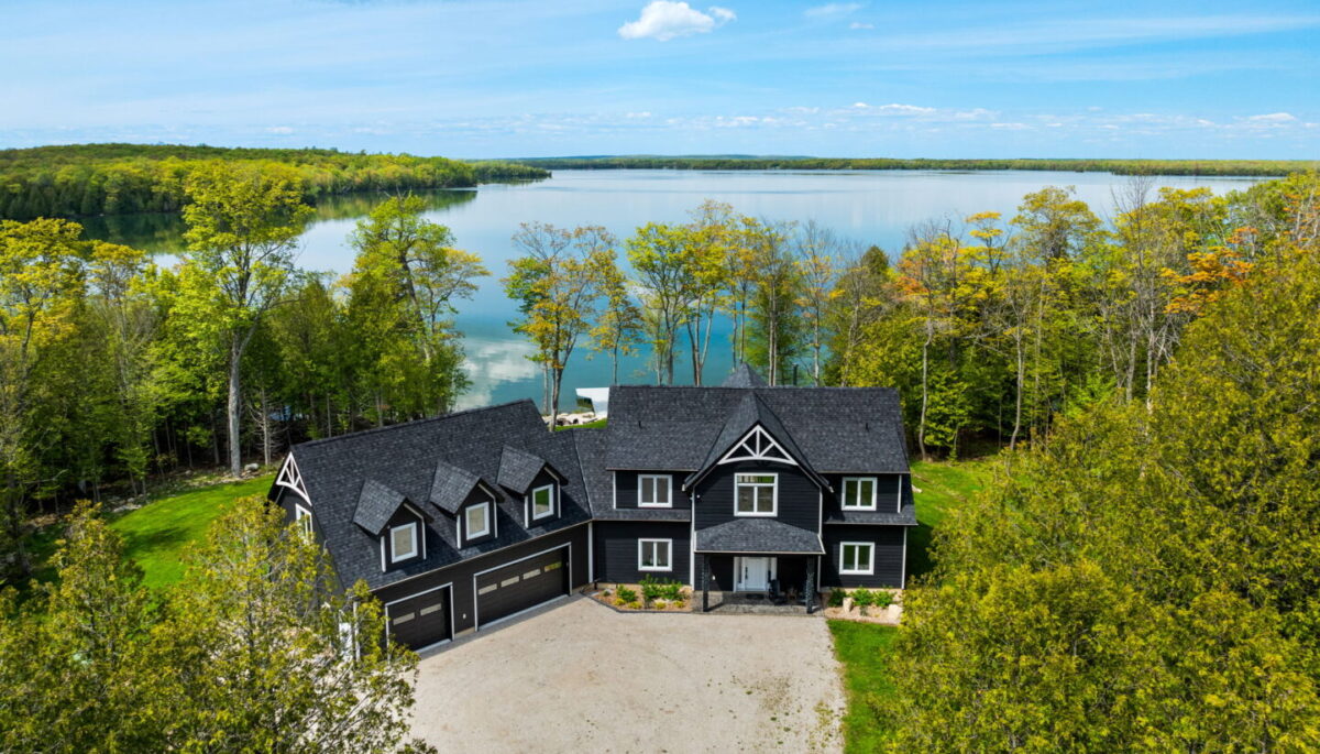 Luxury Lake Manitou property surrounded by trees and private shoreline.