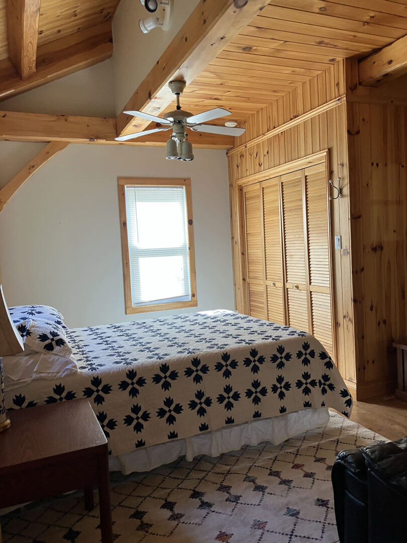 A black and white bed in a wood room