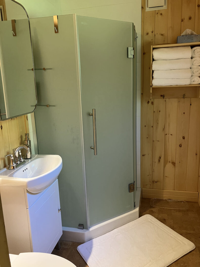 A wood bathroom with a glass walk-in shower