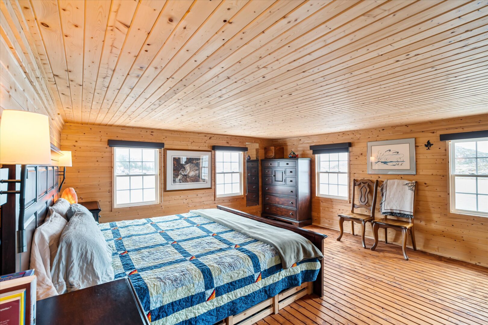 Spacious upstairs bedroom with multiple windows and natural wood finishes