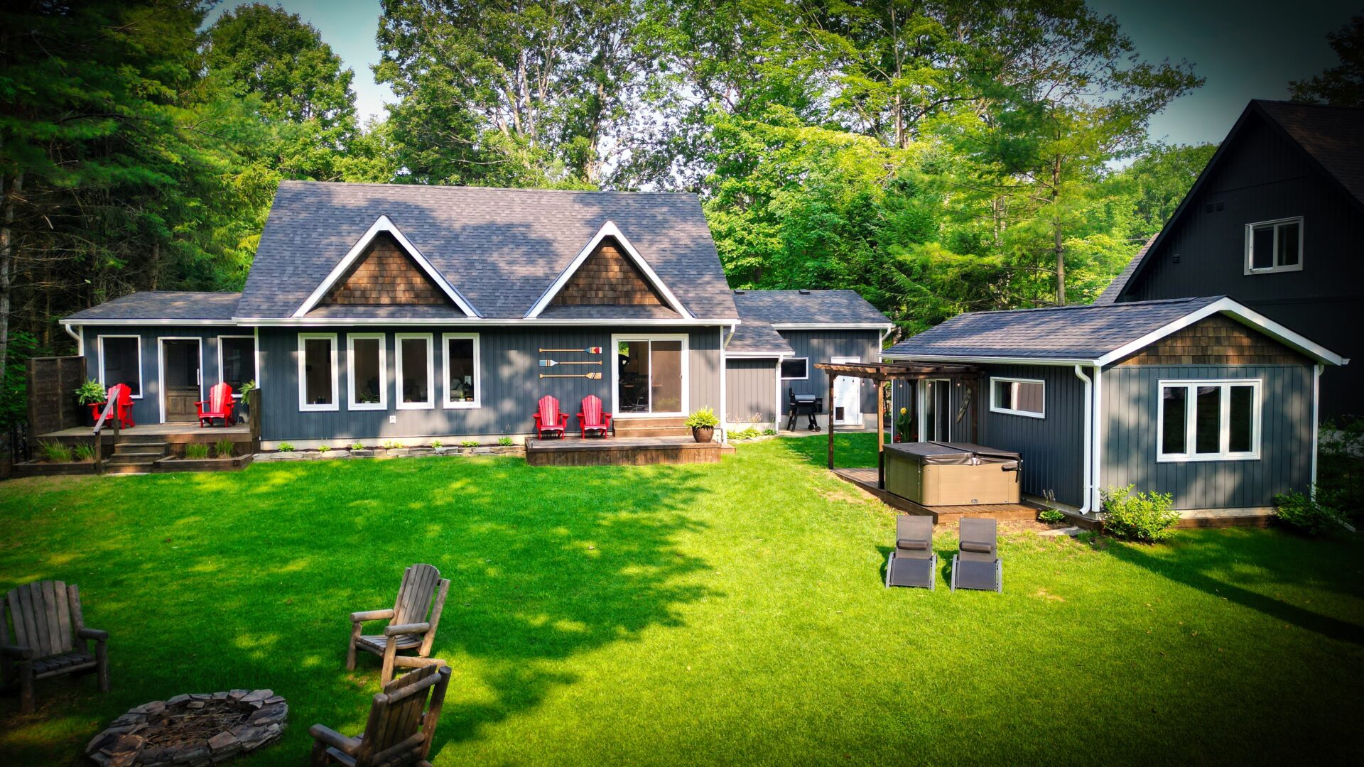 A blue-grey paneled cottage on a vibrant grassy lawn