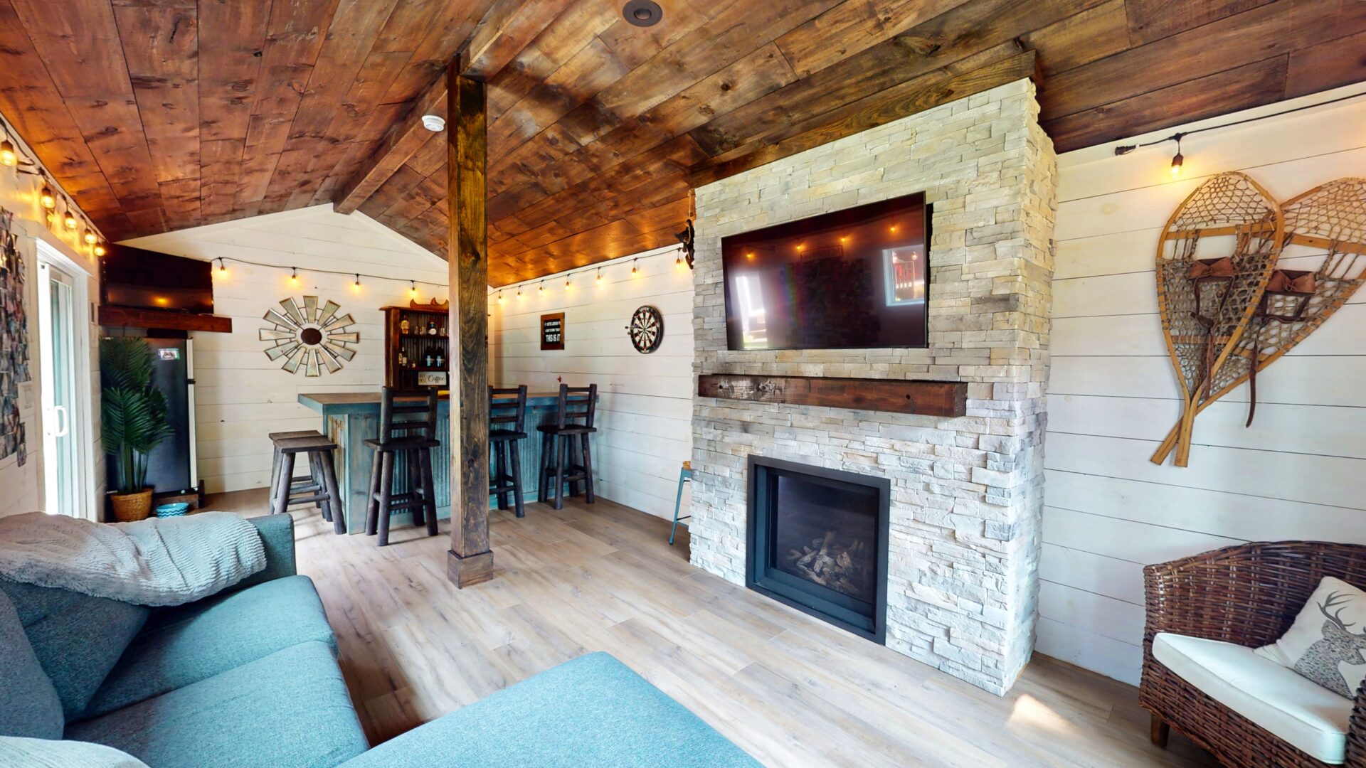 A stone fireplace faces a blue couch